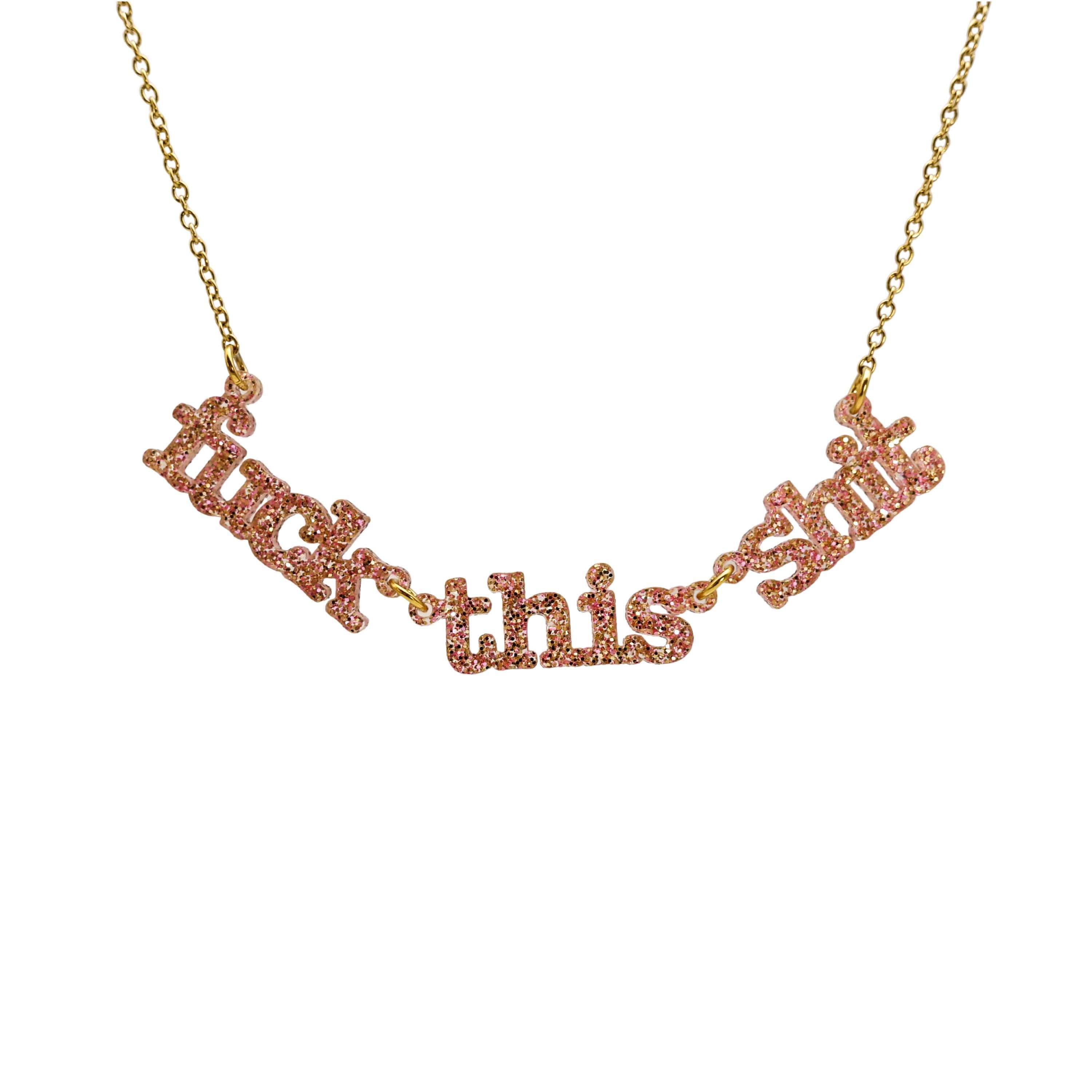 F*ck this Sh*t necklace in pink fizz glitter shown hanging on a gold-plated stainless steel chain against a white background.