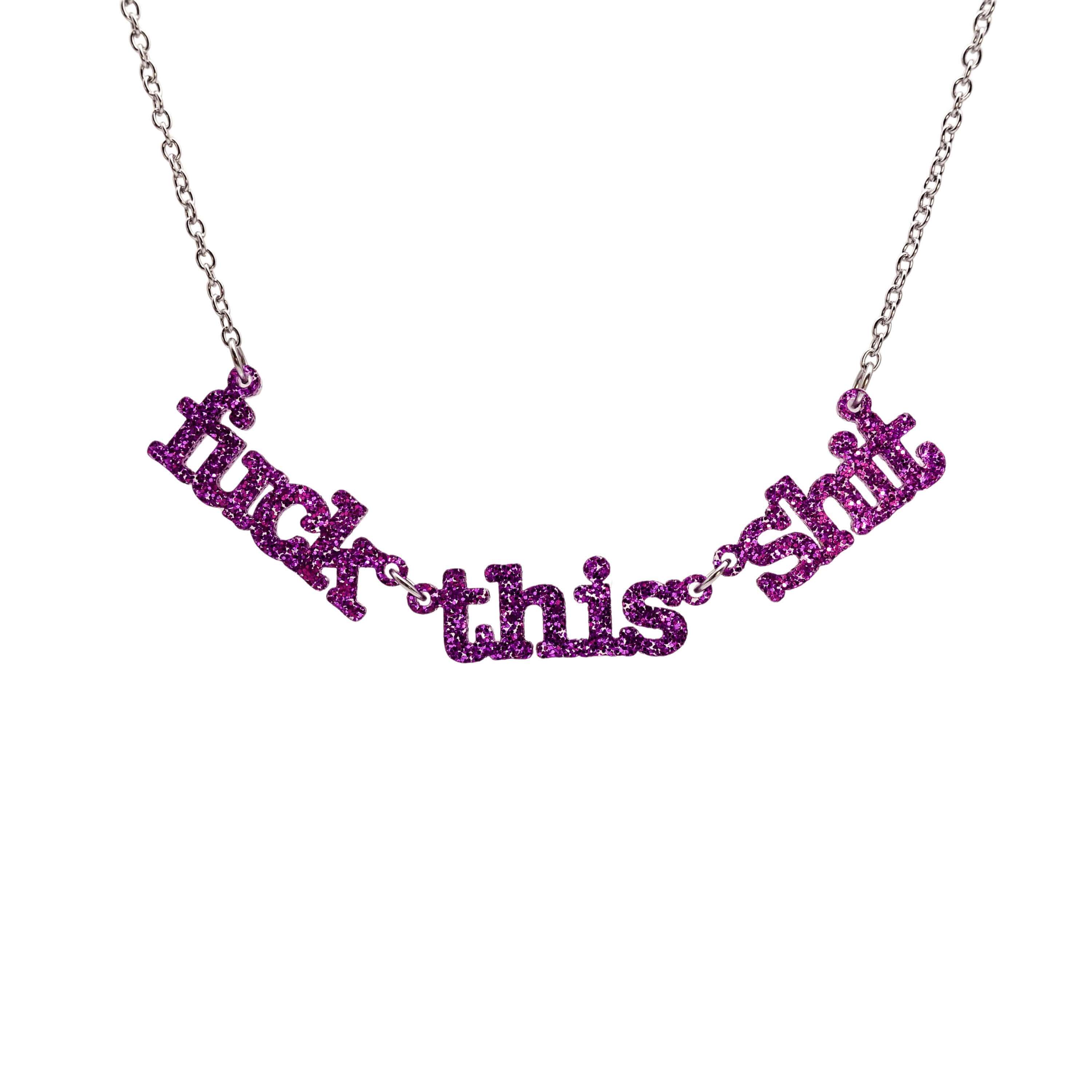 F*ck this Sh*t necklace in purple glitter shown hanging on a stainless steel chain against a white background.