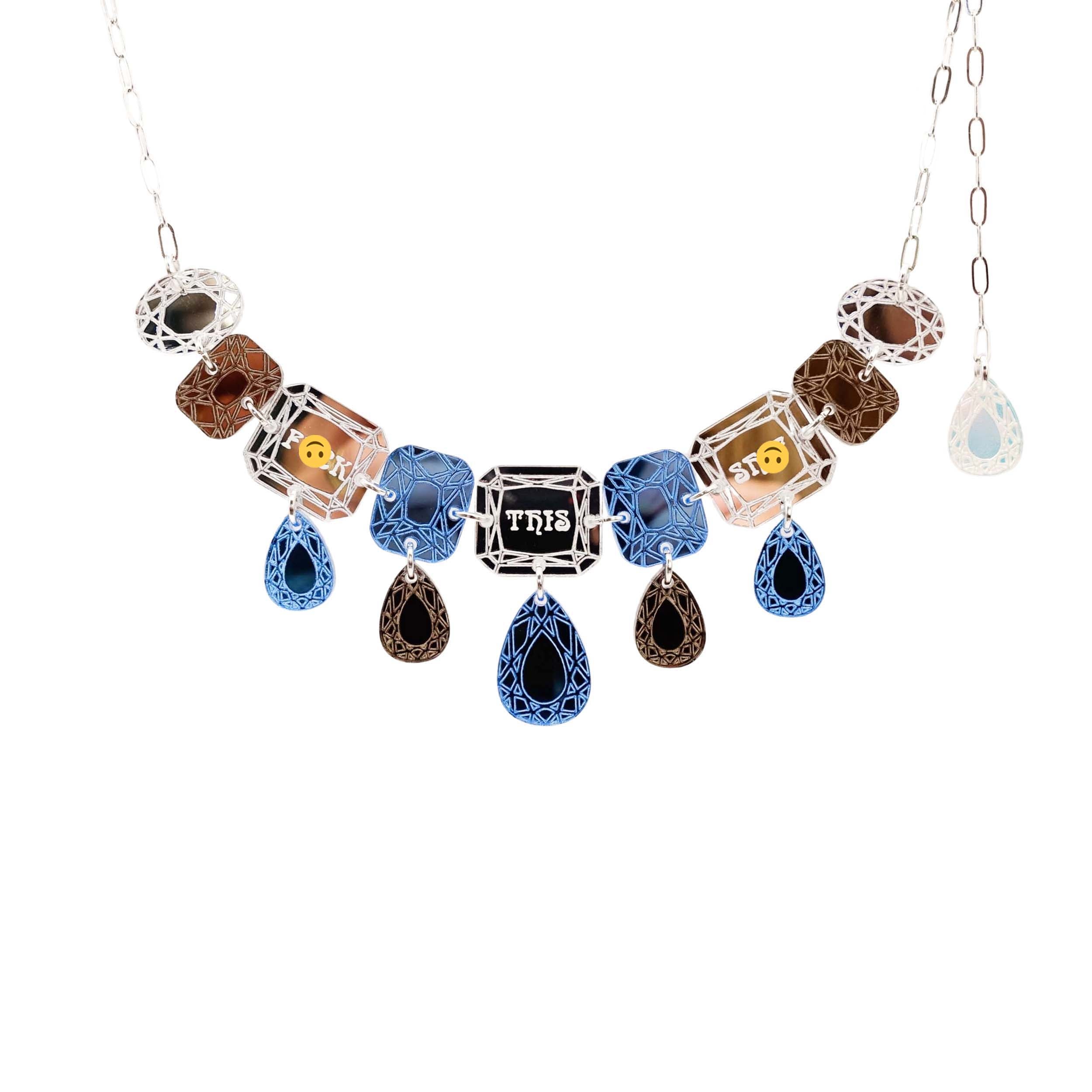 A blue silver and bronze F*ck this Sh*t jewel necklace shown hanging against a white background. 