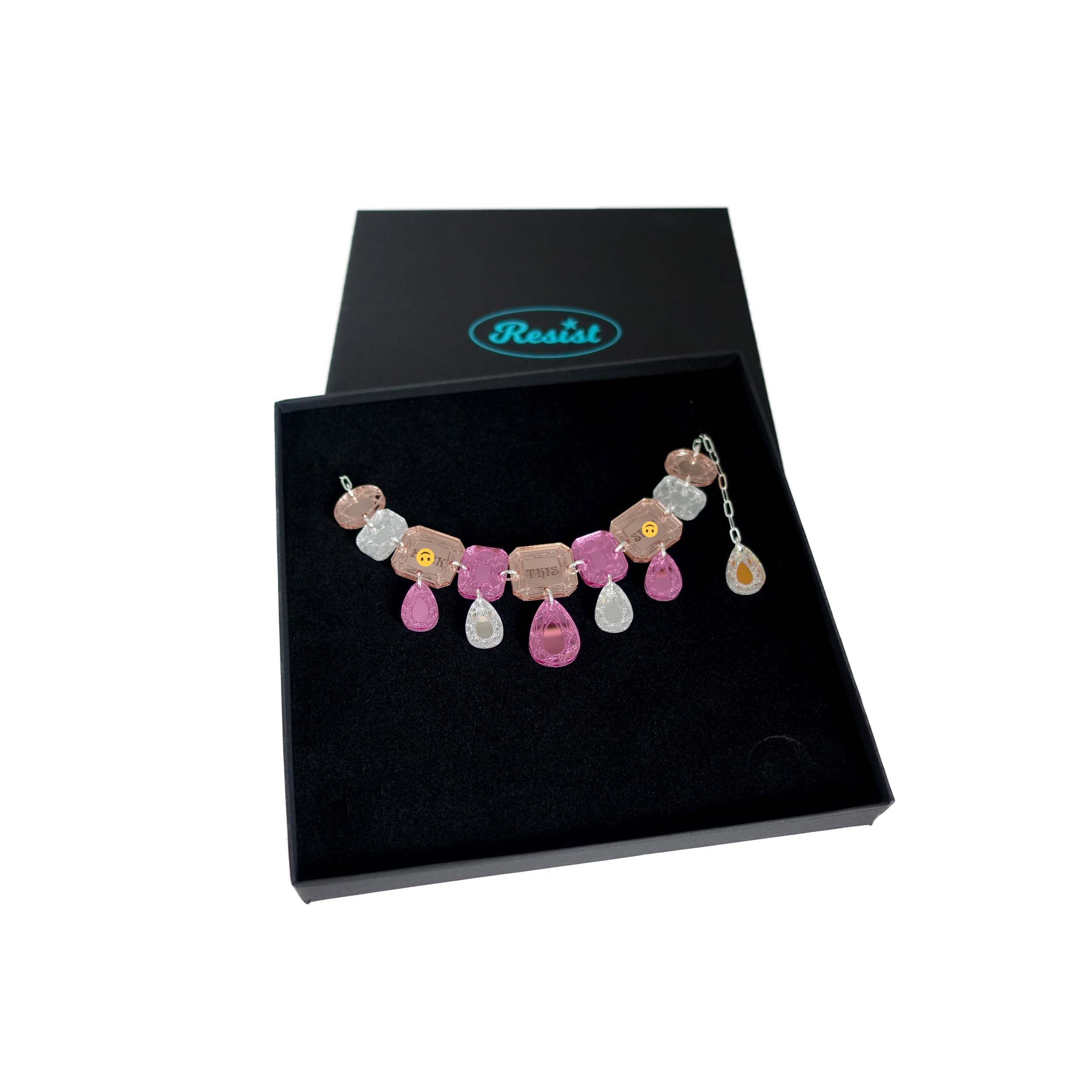 A pink, rose gold and silver F*ck this Sh*t jewel necklace shown in a Wear and Resist gift box. Sweary jewels!  