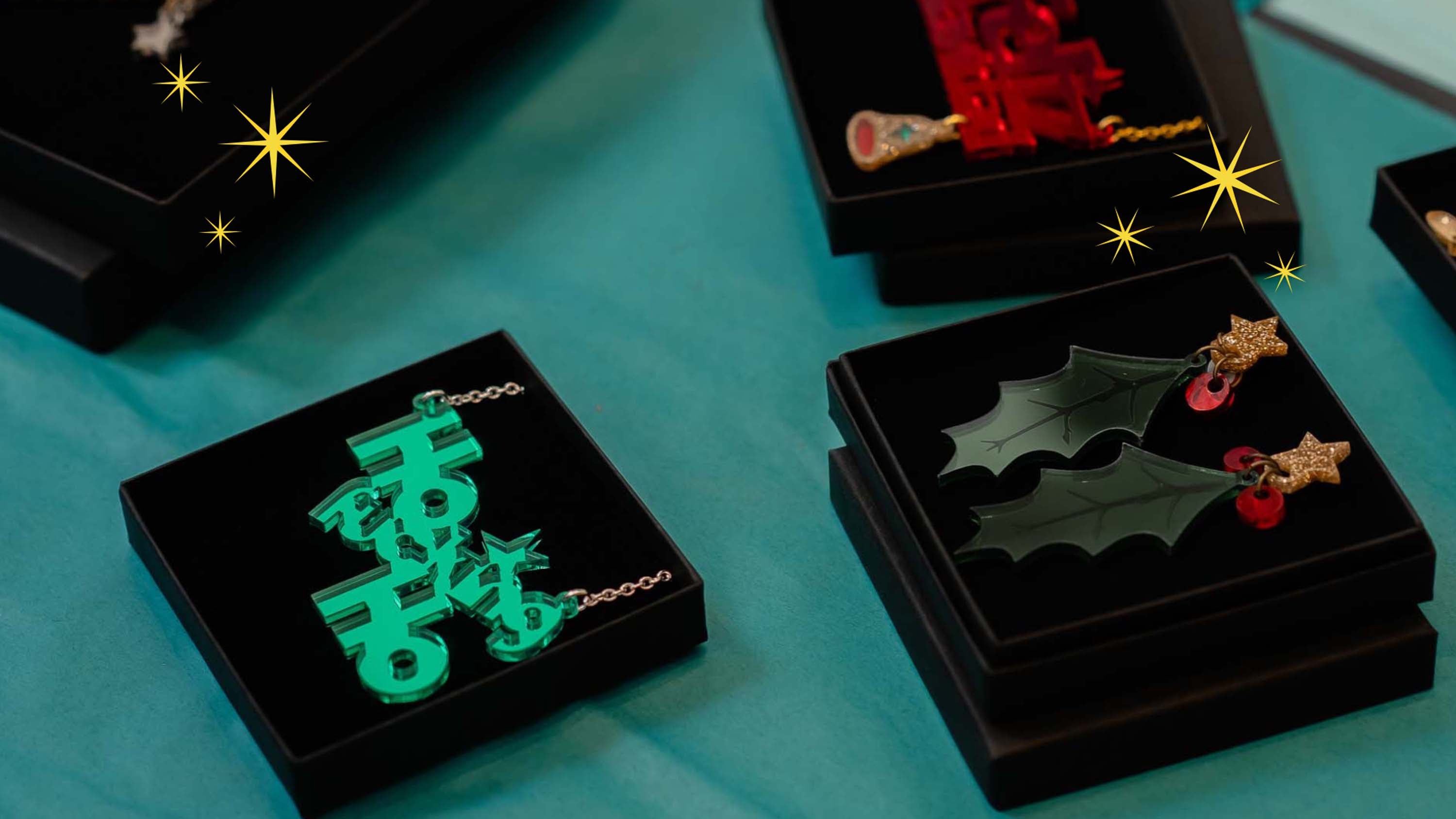 Jewelry boxes with festive designs on teal tissue paper