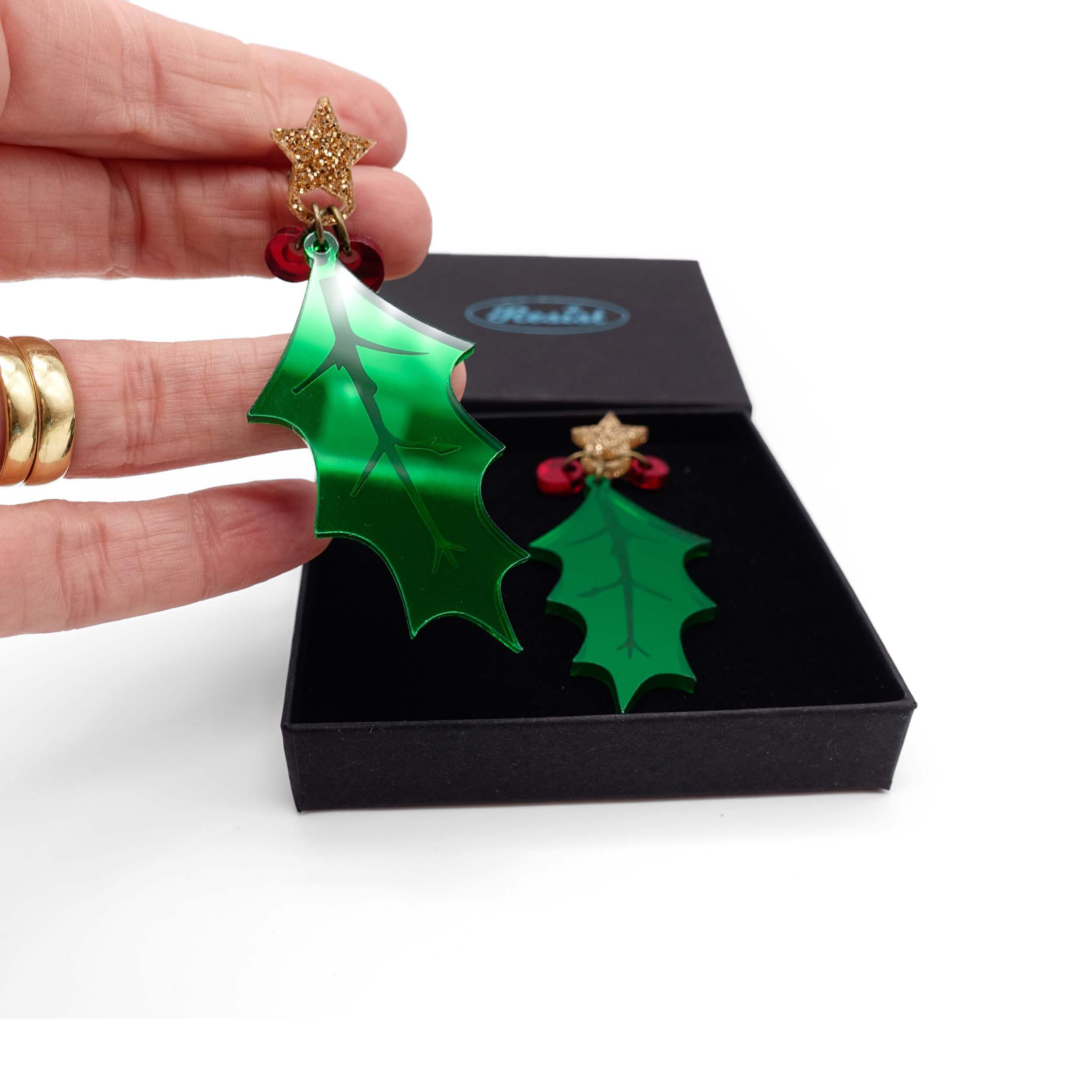 Statement Holly earrings shown being lifted out of a Wear and Resist gift box. 