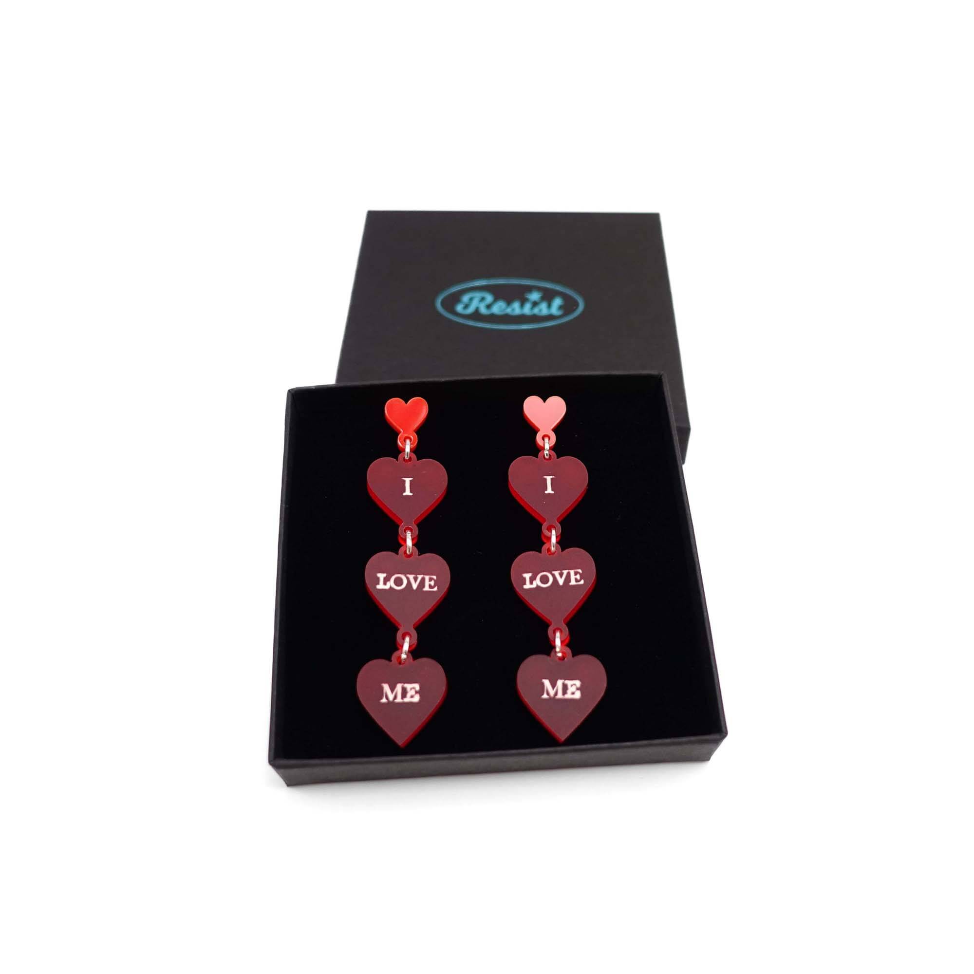 I Love Me heart drop earrings in red frost, shown in a Wear and Resist gift box. 