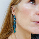 Sarah Day, founder of Wear and Resist, wears teal frost  I am I am I am heart drop earrings