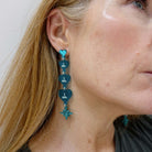 Sarah Day, founder of Wear and Resist wears teal frost  I am I am I am heart drop earrings. 