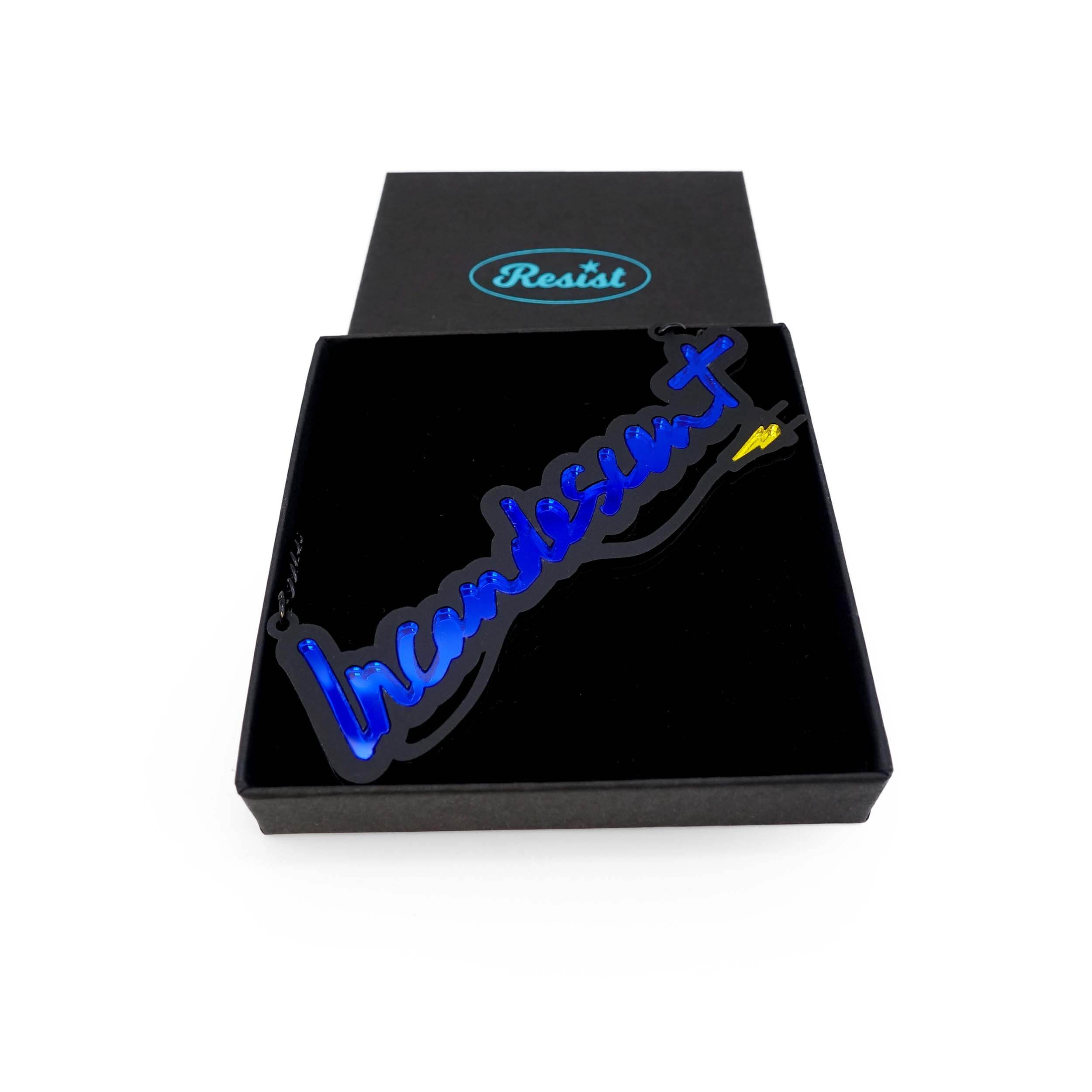 An Incandescent neon necklace in electric blue shown in a Wear and Resist gift box. 