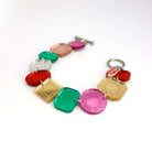 Jewel bracelet with stainless steel toggle clasp shown lying on a white surface. 