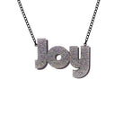 Joy statement necklace in silver glitter, with slate frost drop shadow backing layer. Shown hanging against a white background. 