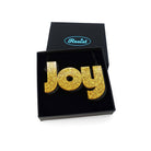 Joy statement necklace in ultra gold glitter, shown in a Wear and Resist gift box. 