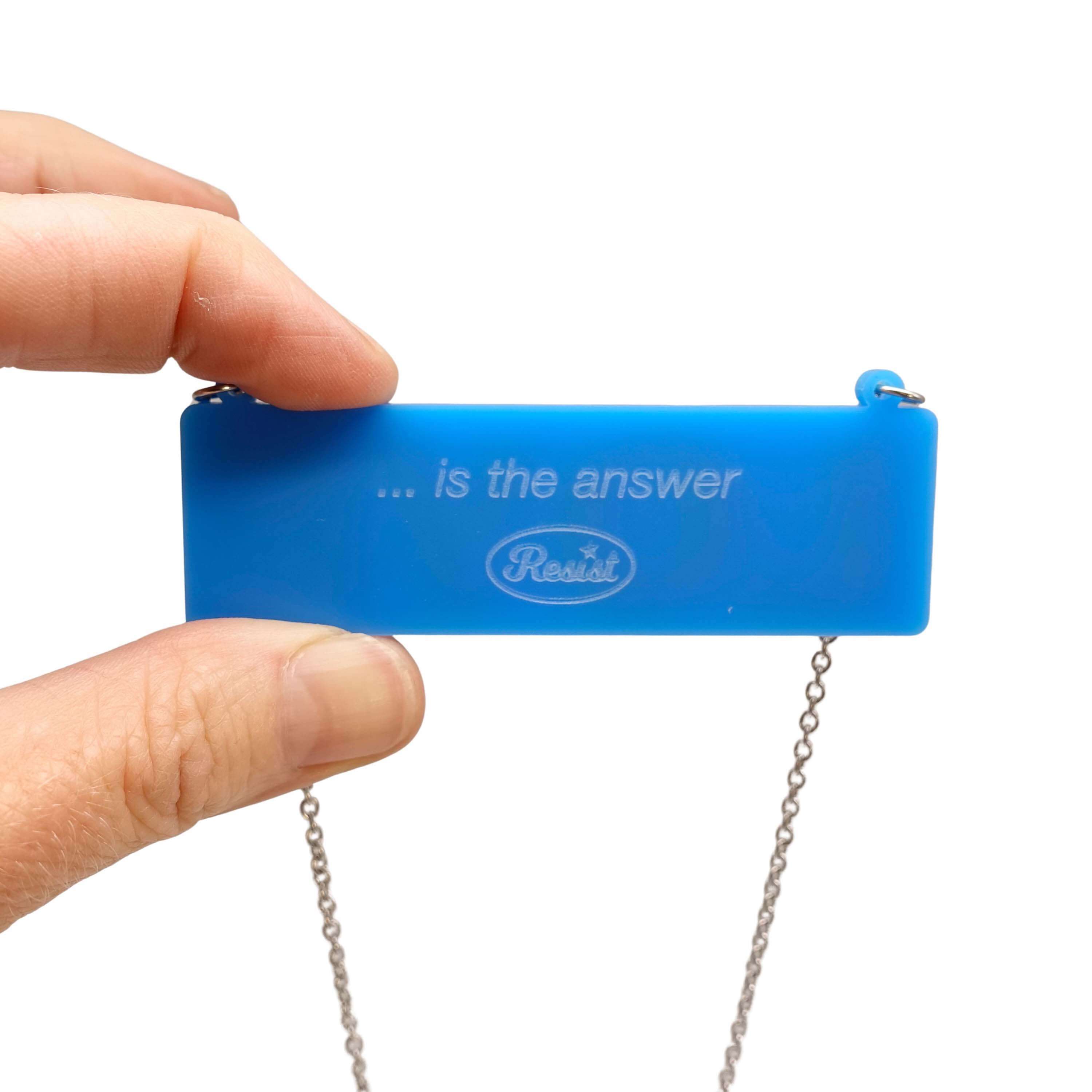 The back of the LOVE necklace etched with '... is the answer' and the Wear and Resist logo. 