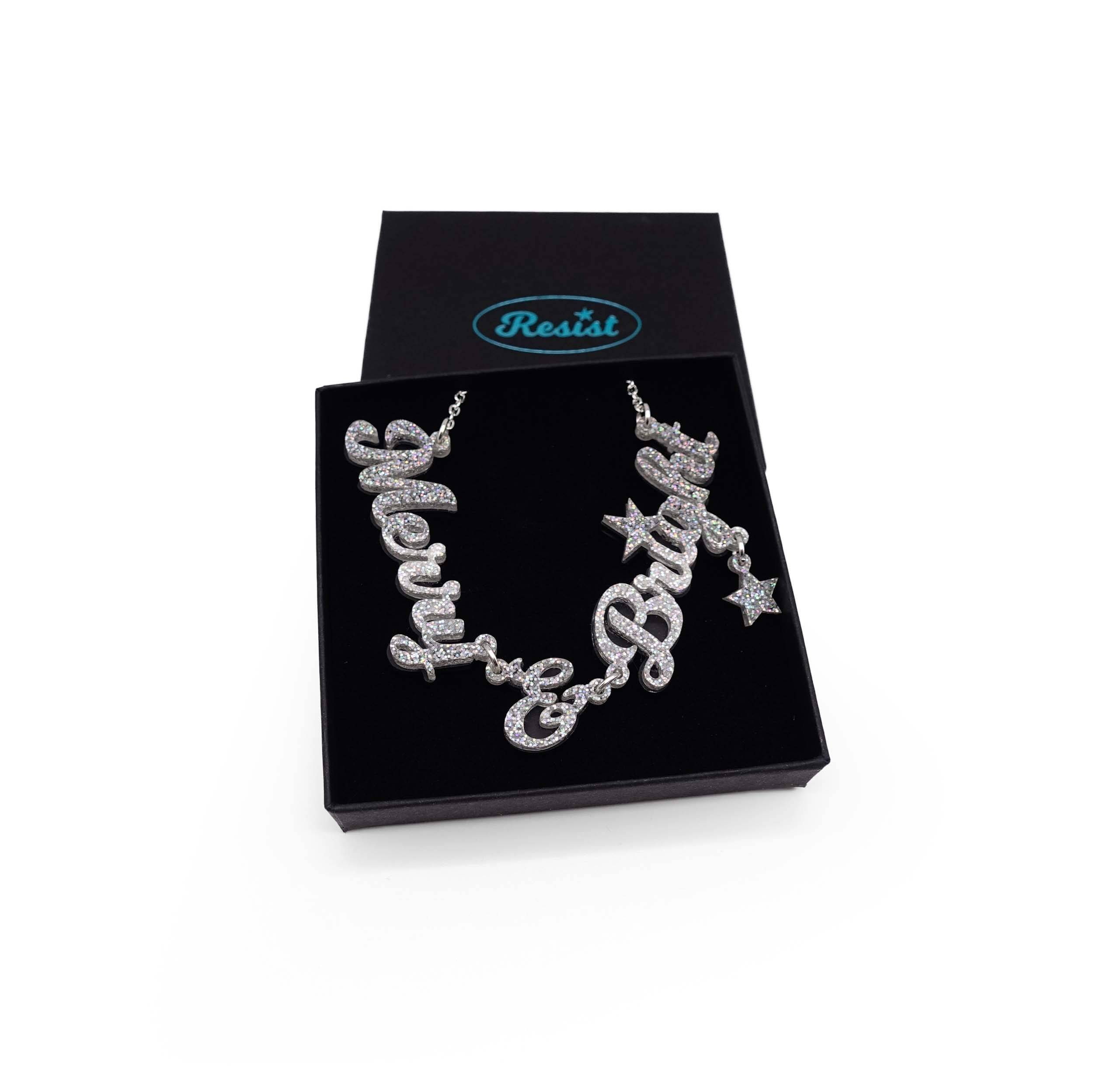 Merry & Bright necklace in silver glitter on a silver chain, shown in a Wear and Resist gift box. 