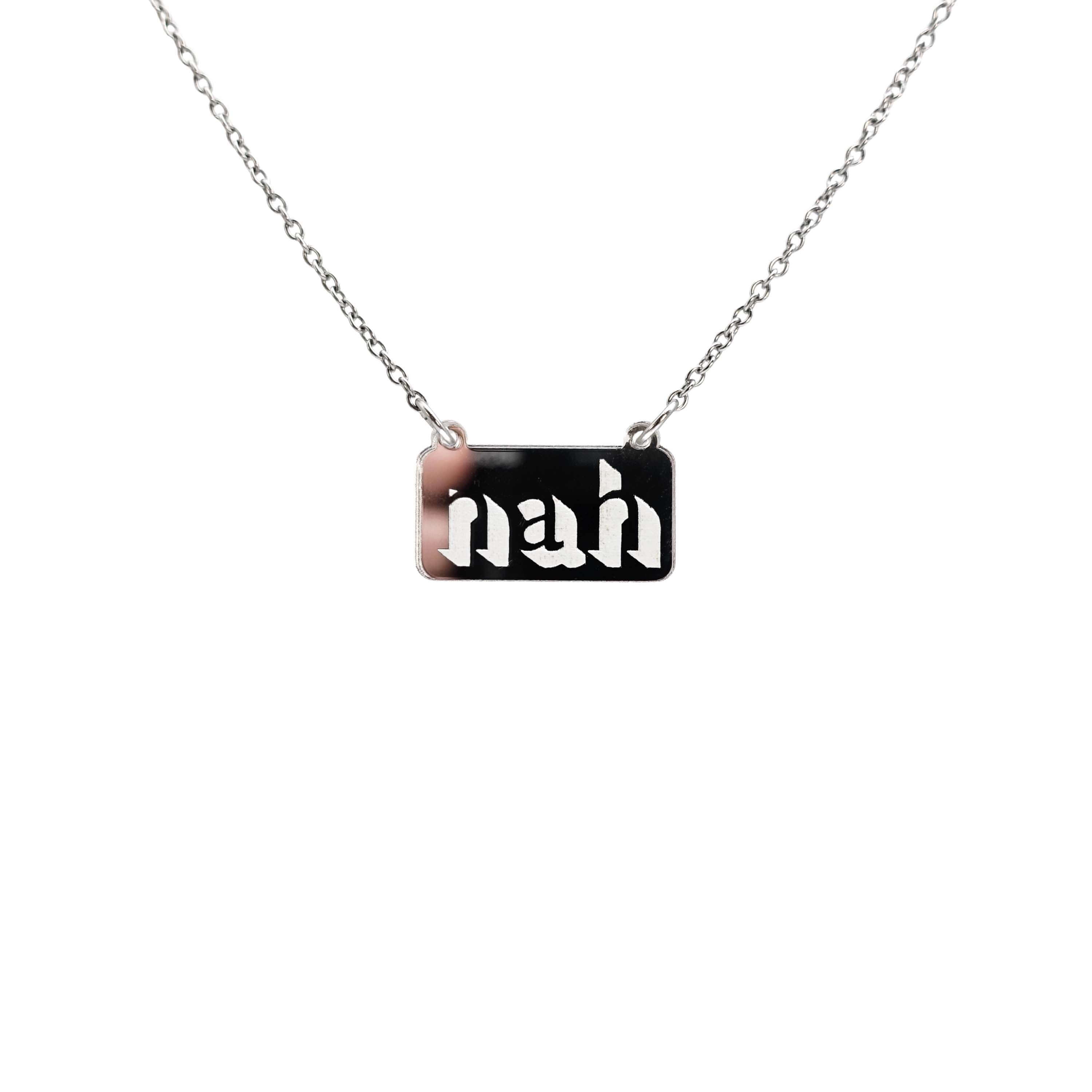Nah necklace in silver mirror on a stainless steel chain hanging against a white background. 