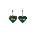 Nah Nope heart shaped huggie hoop earrings in silver mirror shown hanging against a white background. 