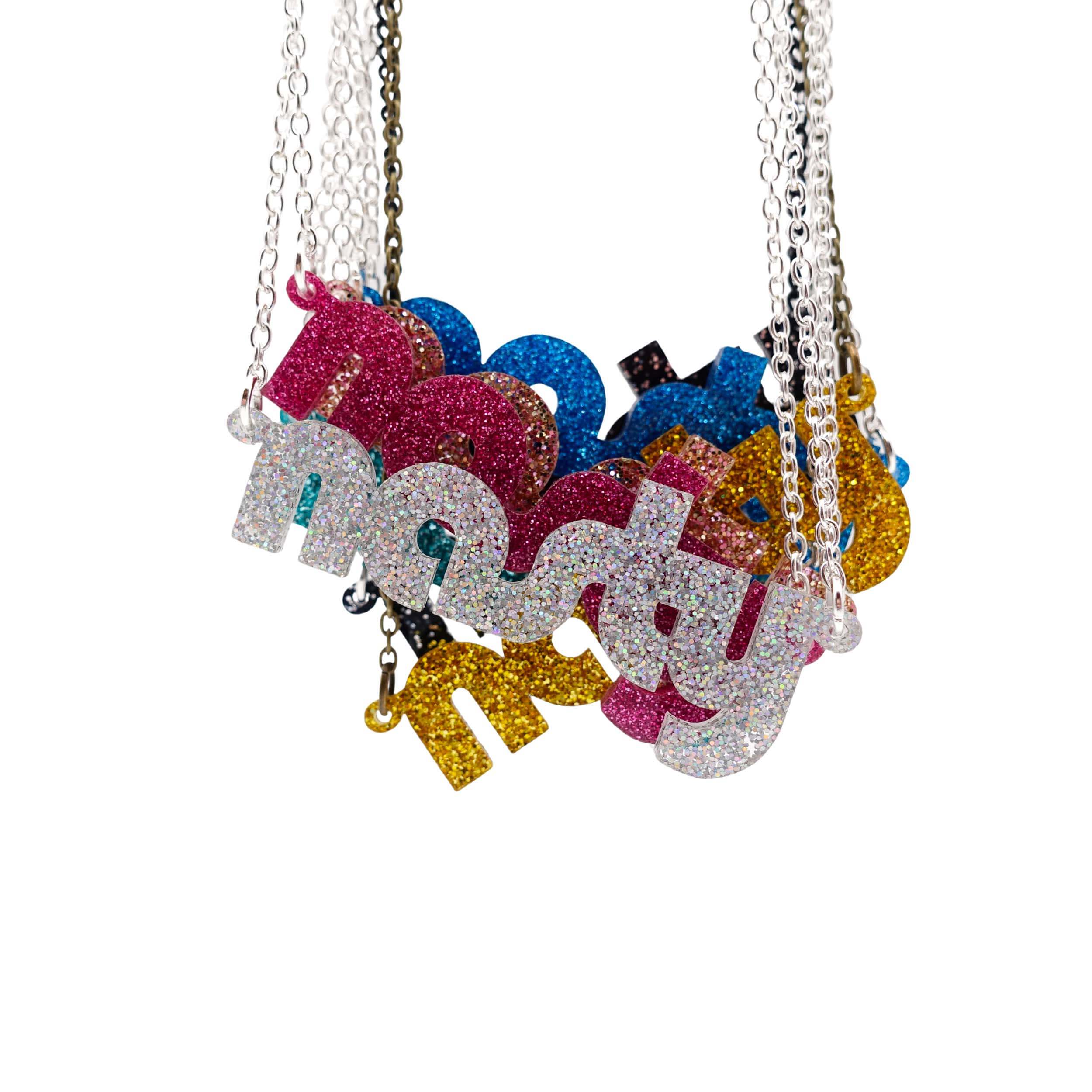 Nasty necklaces in glitter colours shown hanging together. 