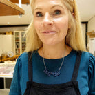 Sarah wears a Welsh sweary Nefi blw (navy blue!) necklace in her studio. 