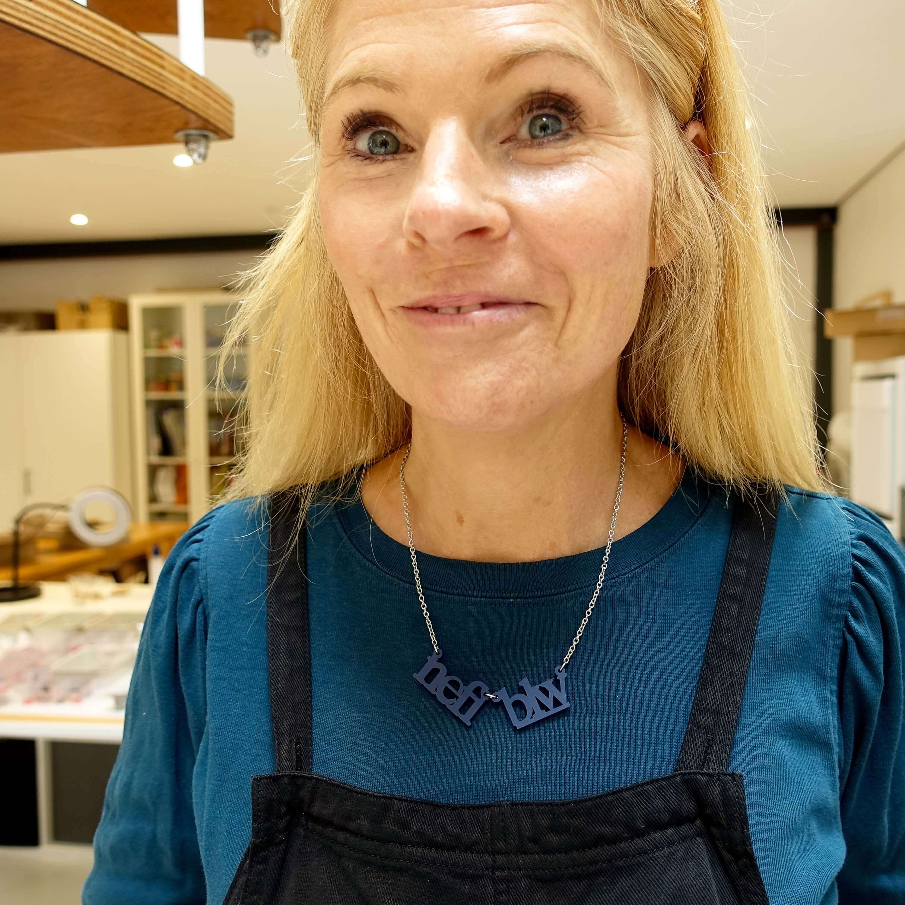 Sarah wears a Welsh sweary Nefi blw (navy blue!) necklace in her studio. 