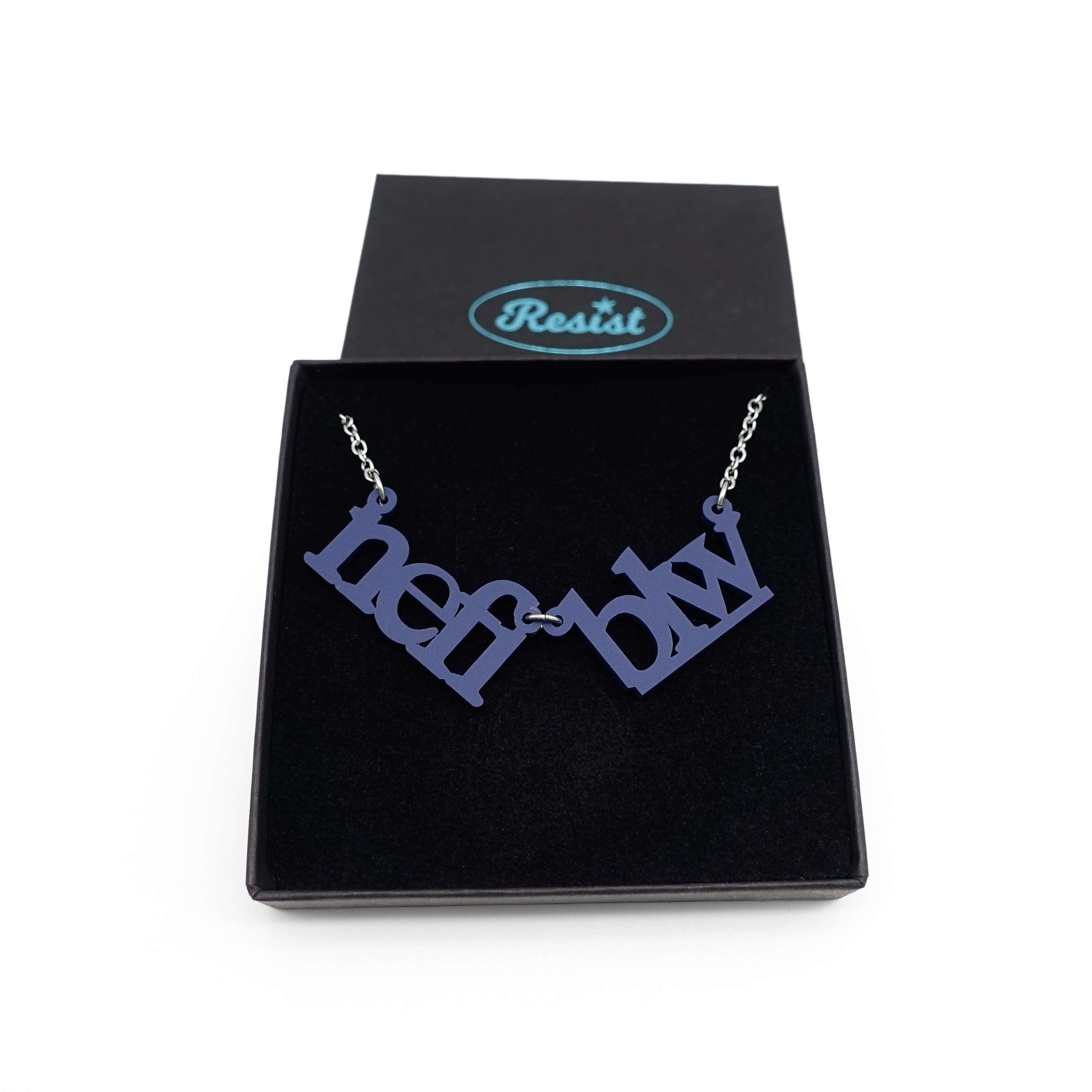 Welsh sweary Nefi blw (navy blue!) necklace shown in a Wear & Resist gift box. 