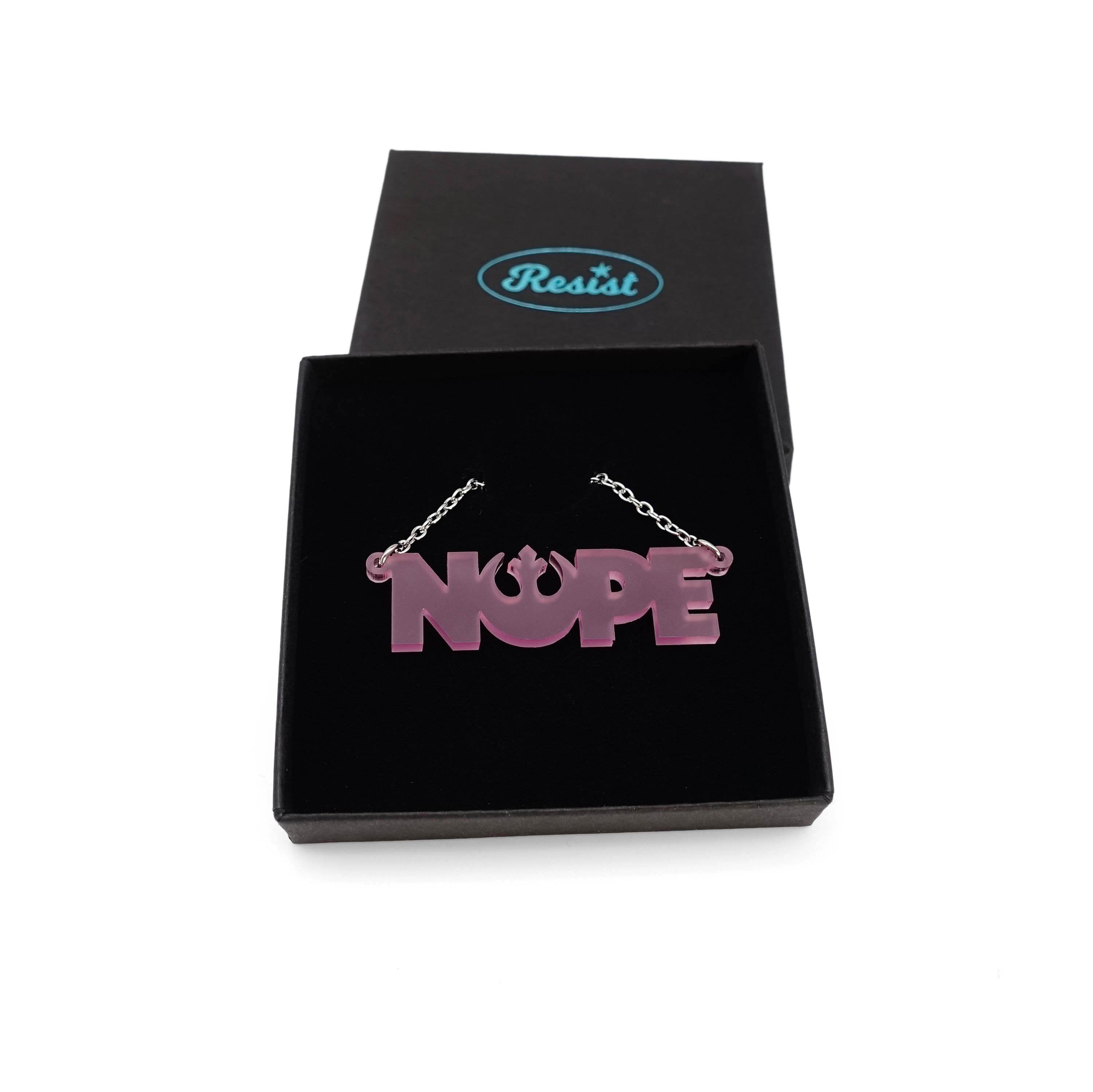 Nope necklace with Rebel Alliance symbol in pale pink frost, shown in a Wear and Resist gift box. 