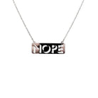 Nope necklace in silver mirror on a stainless steel chain hanging against a white background. 