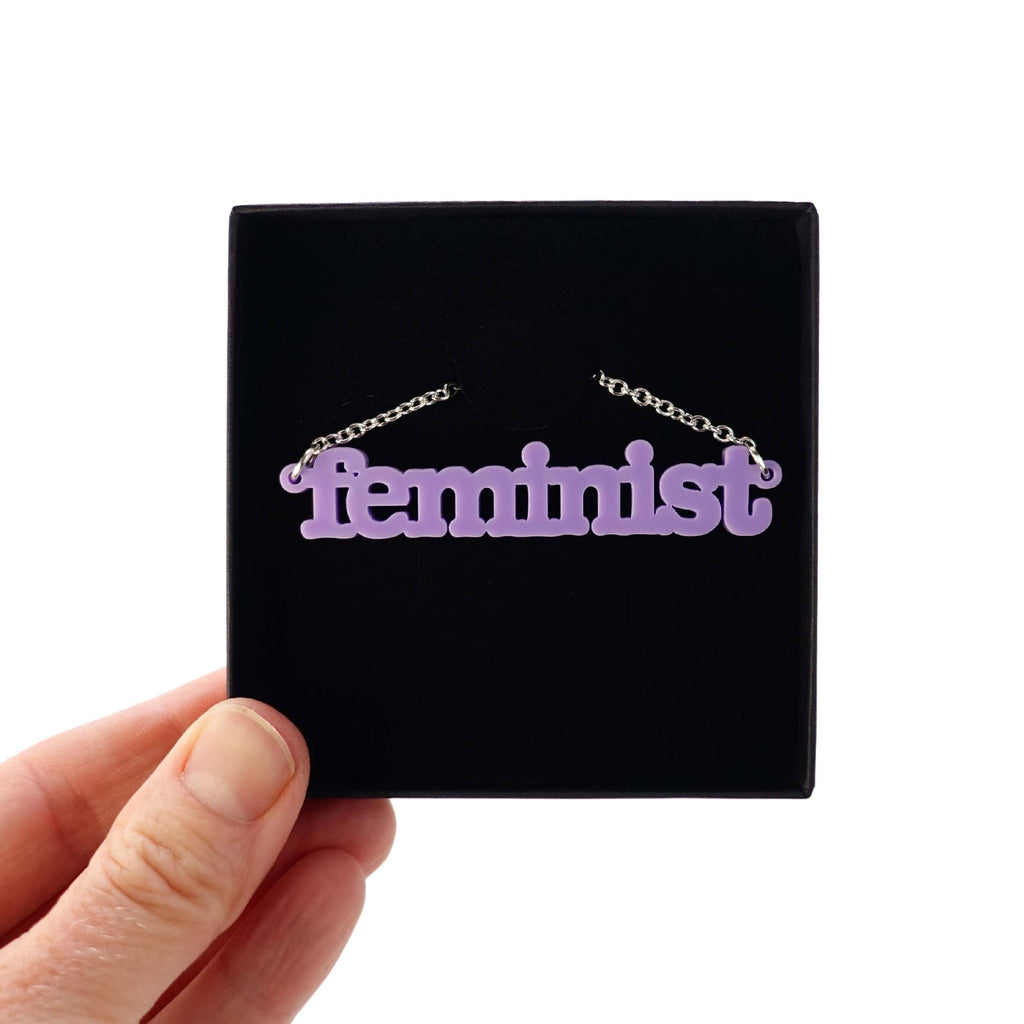 Parma violet Feminist necklace shown in a Wear and Resist gift box. 
