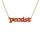 Typewriter Resist necklace in flame glitter shown hanging on a gold plated stainless steel chain against a white background. 