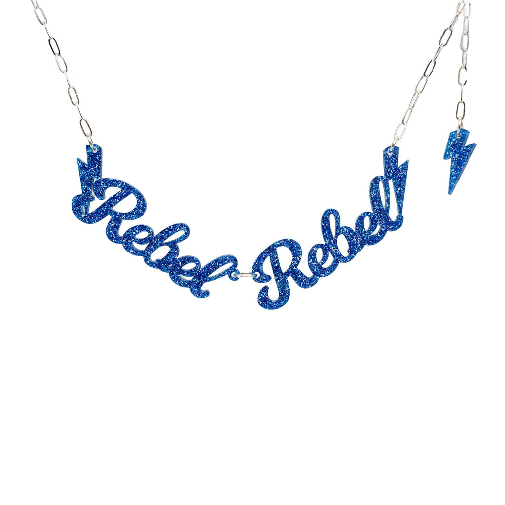 Rebel Rebel necklace in blue glitter by Sarah Day for Wear and Resist shown hanging against a white background. 