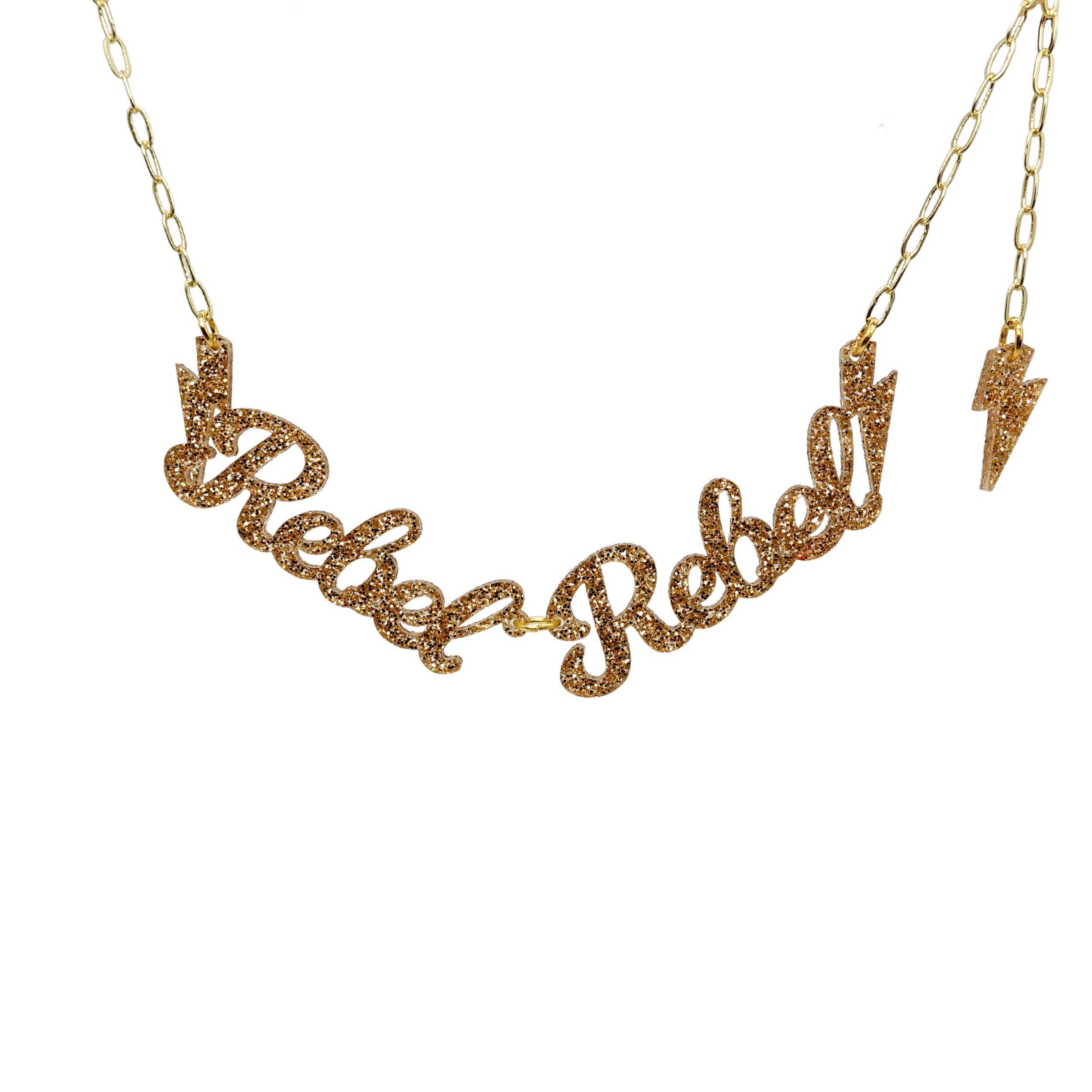 Rebel Rebel necklace in gold glitter on a gold paperclip chain shown hanging against a white background. 