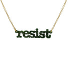 Typewriter Resist necklace in moss glitter shown hanging on a gold plated chain against a white background. 