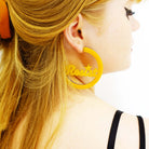 Eliza wears Resist and Persist statement hoops in sunflower yellow. Designed by Sara Day for Wear and Resist. 