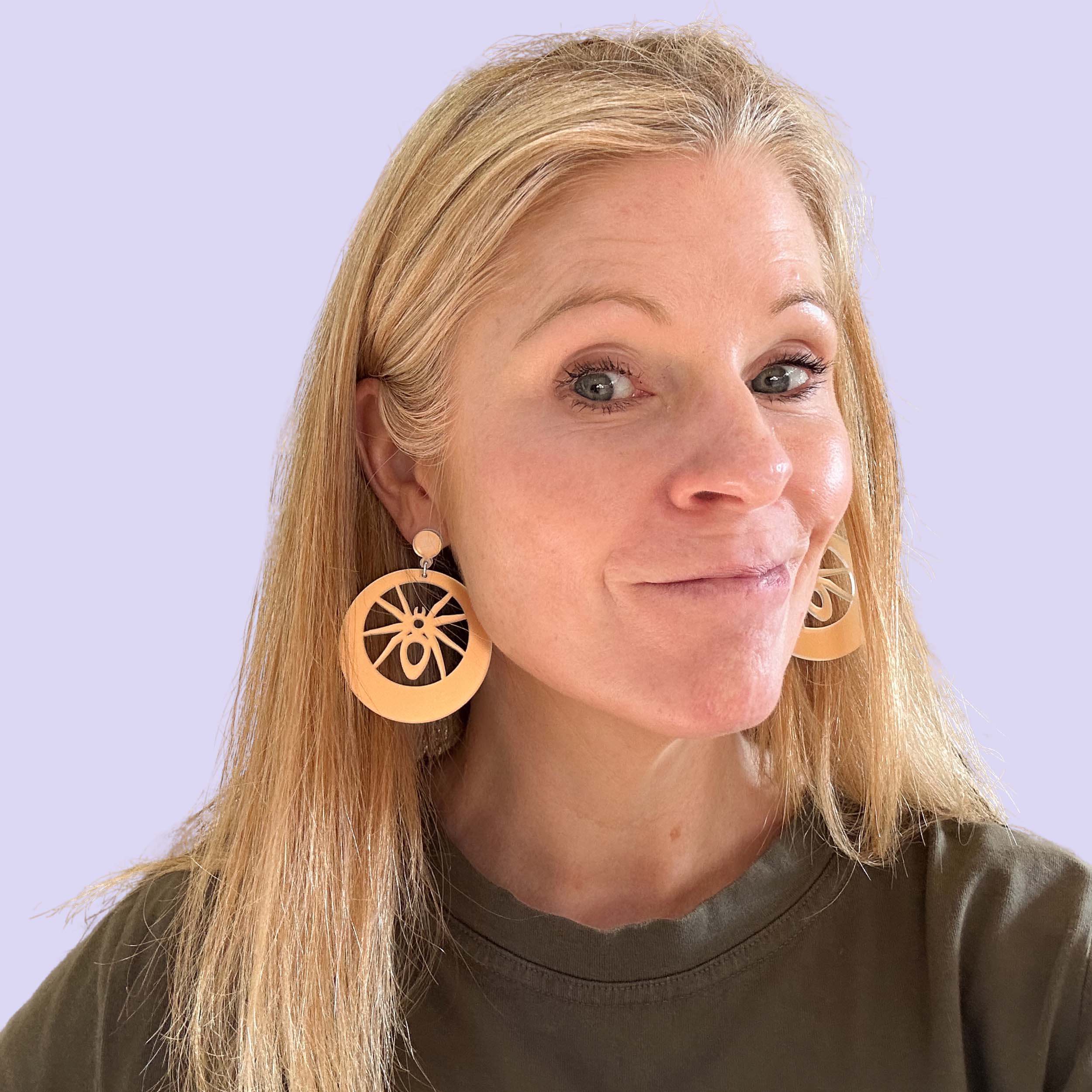 Sarah Day, founder of Wear and Resist wears the new matte iridescent spider hoop earrings.