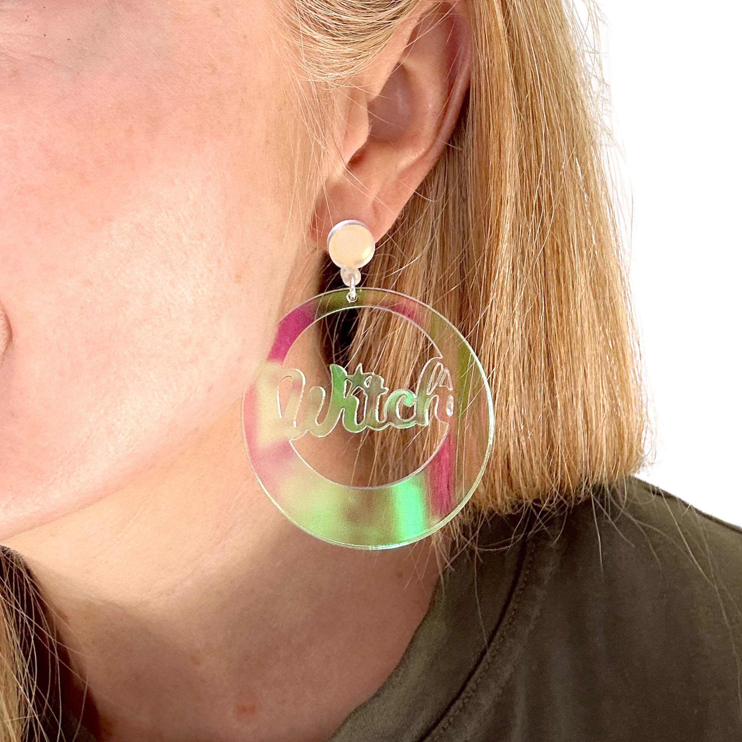 A close up of Sarah wearing the Witch iridescent hoop earrings,  