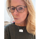 Sarah wears a small sweary necklace. 