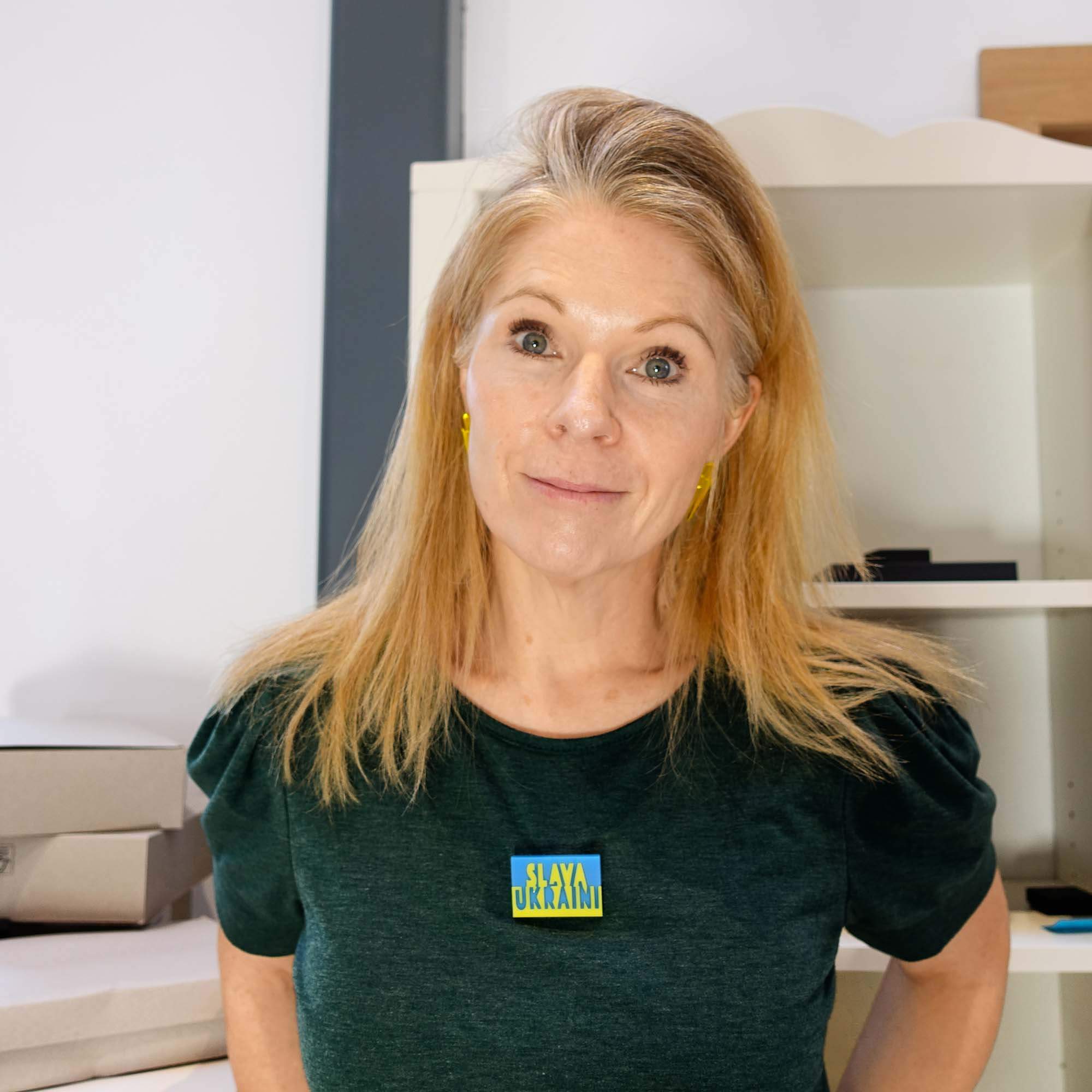 Sarah Day, founder of Wear and Resist wears the Slava Ukraini brooch in her studio. 