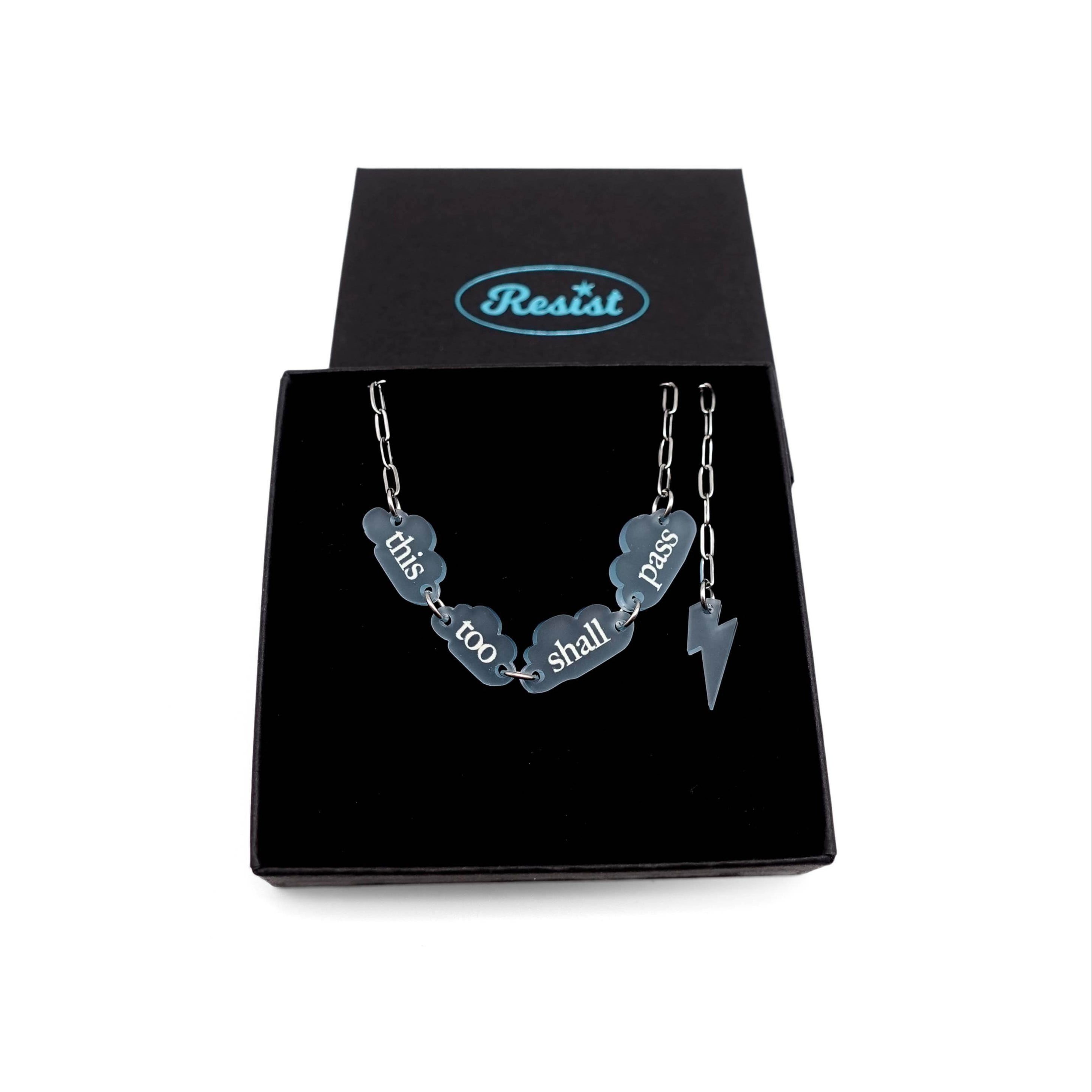 This Too Shall Pass floating clouds necklace shown on a stainless steel chain in a Wear and Resist gift box.
