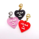 Heart charms etched and hand-painted with the words All shall be well in glow in the dark pigment. 