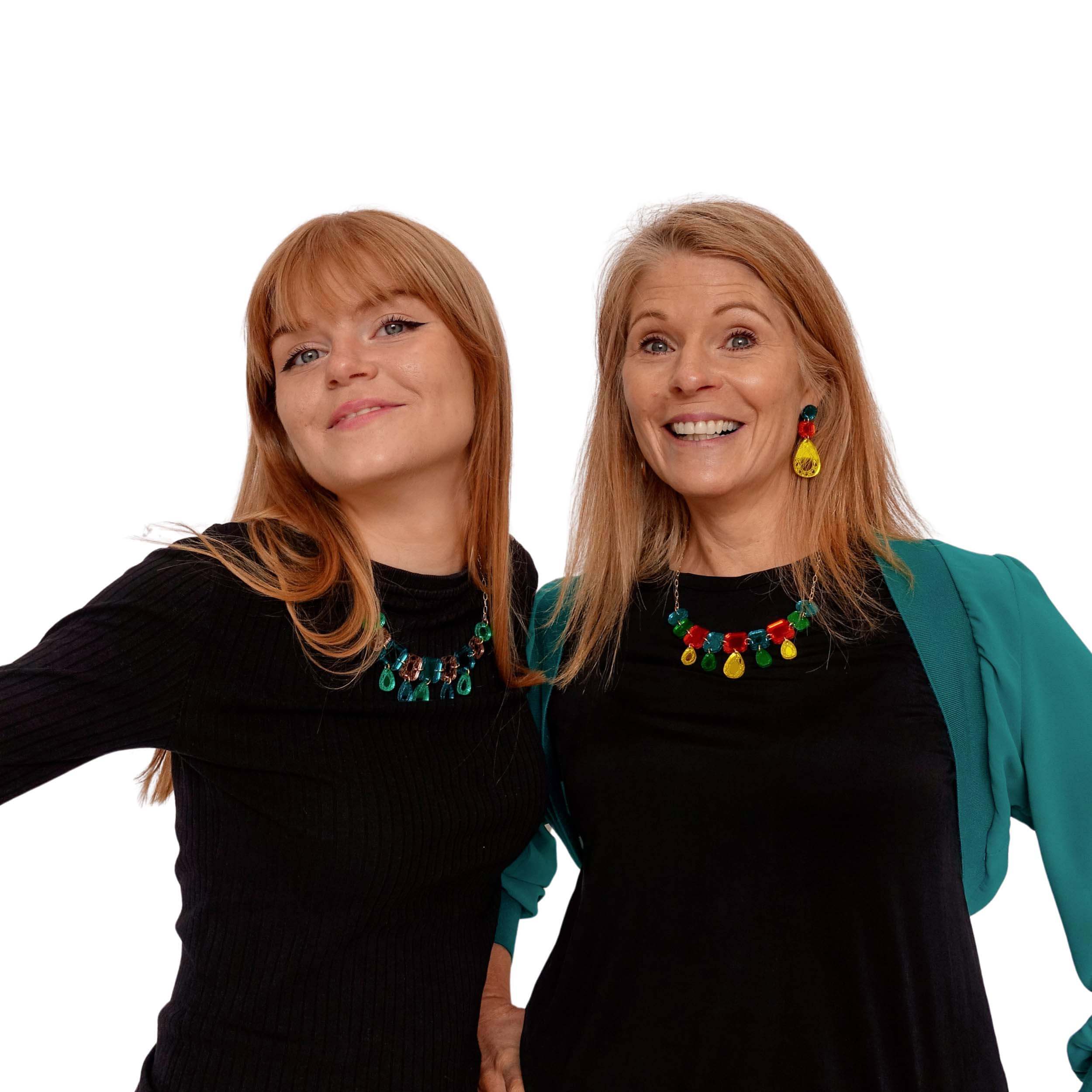Sarah and Eliza modelling necklaces and earrings from The Austerity Jewels collection. Eliza wearing a teal époque necklace and Sarah wearing matching large earrings and necklace in flame mambo. 
