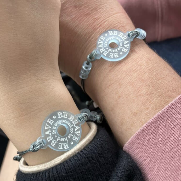Customer review picture of a woman and her daughter both wearing Be Brave bracelets designed by Sarah Day for Wear and Resist. 
