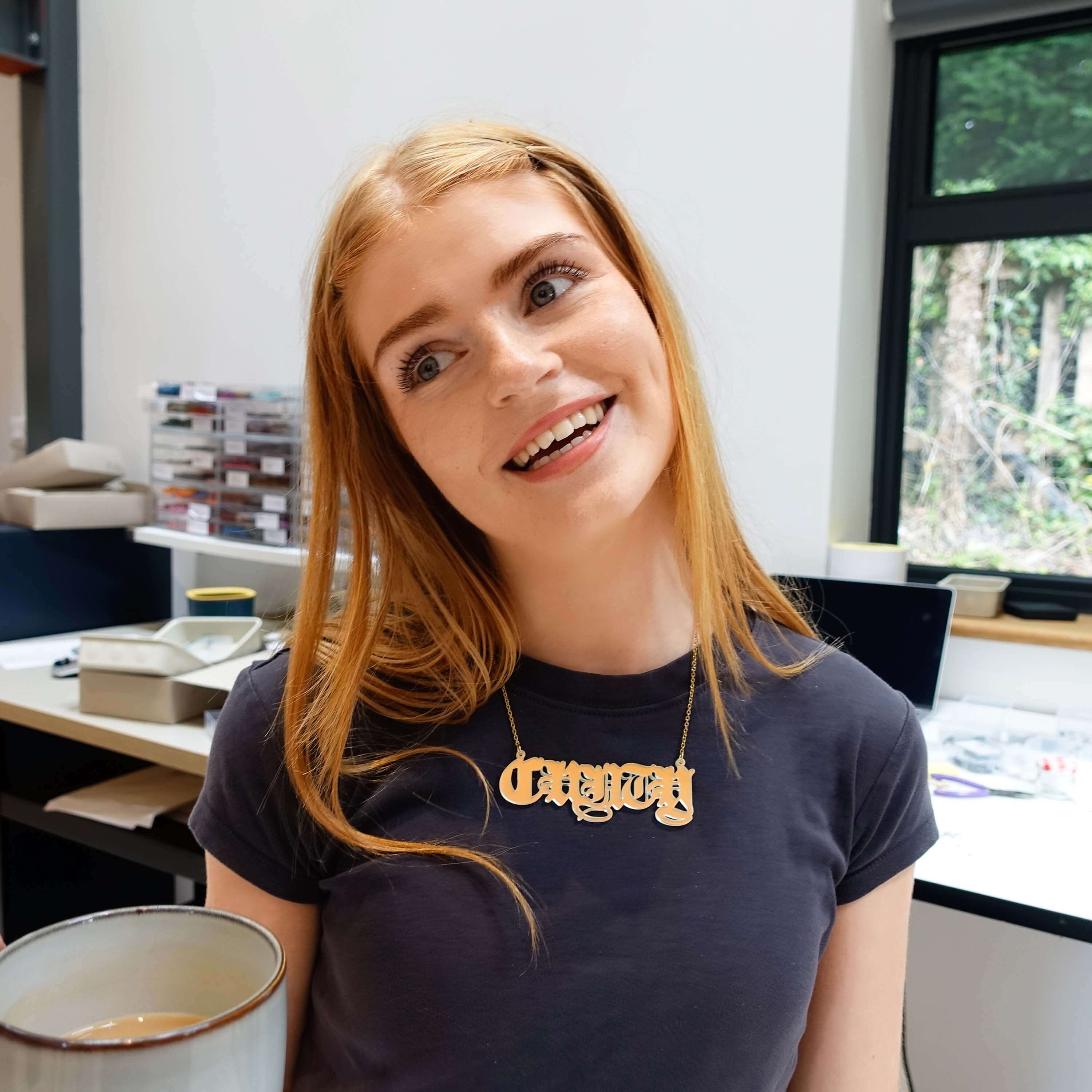 Eliza wears a massive C*nty necklace in matte iridescent in the studio. 