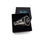 A matte black acrylic brooch in the shape of a megaphone, etched with glow in the dark paint with the words BIN THE BILLIONAIRES, shown in a small Wear & Resist gift box.