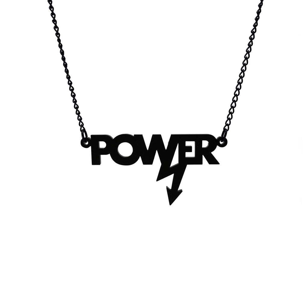 Mini power necklace in matte black shown hanging on a black chain against a white background. Designed in collaboration with Mary Beard for her book Women and Power. 