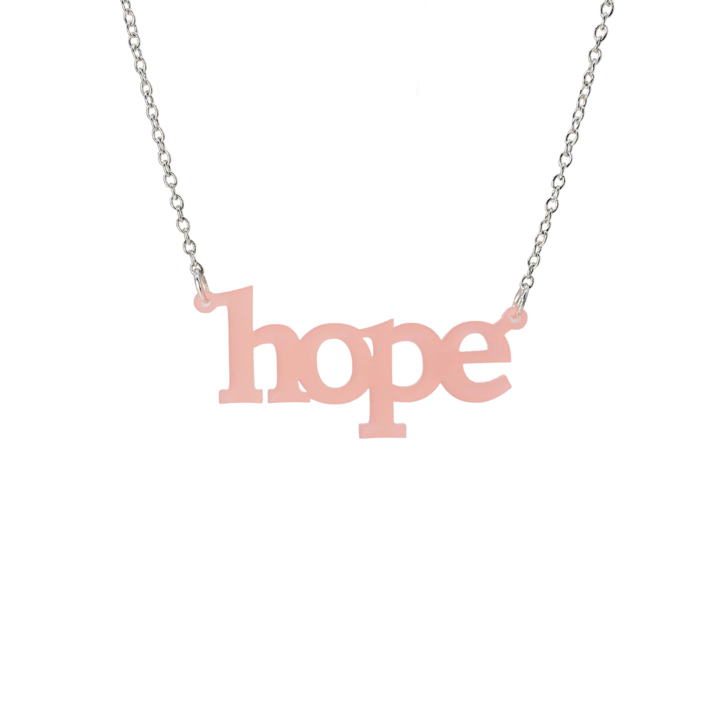 Hope necklace in blush pink shown on a silver chain hanging on a white background. 