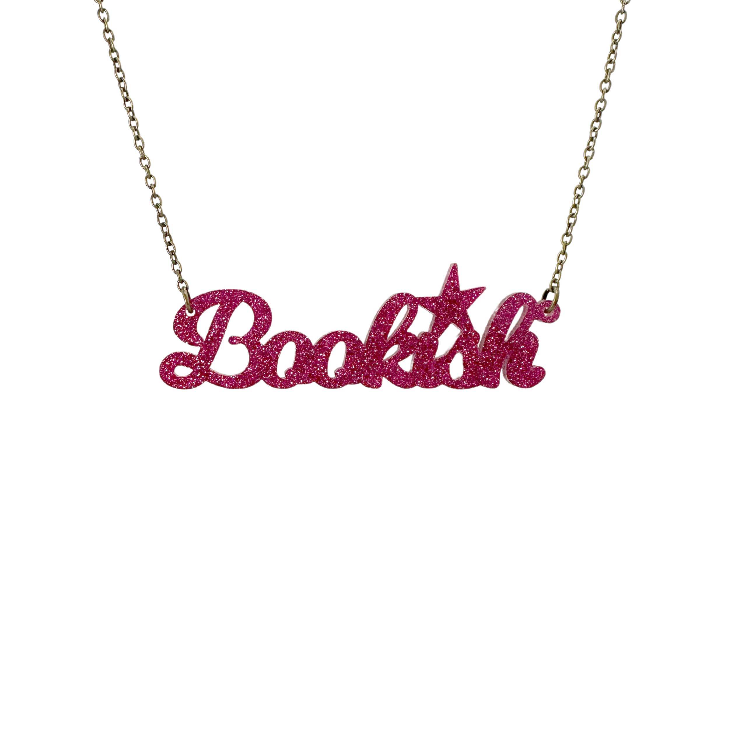 Bookish necklace in hot pink glitter shown hanging against a white backround. 