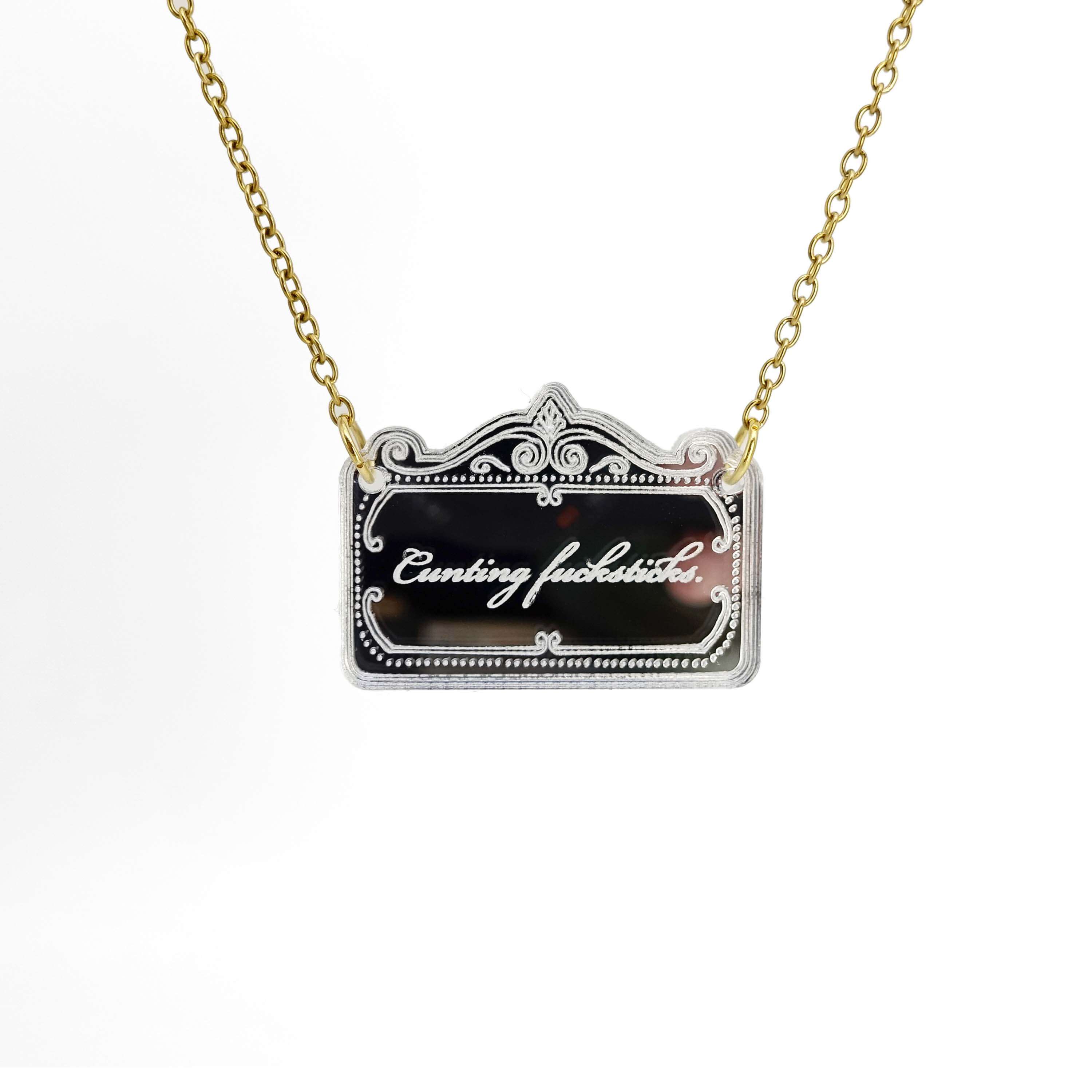 Necklace etched with rude words hanging on a gold ion-plated stainless steel chain. 