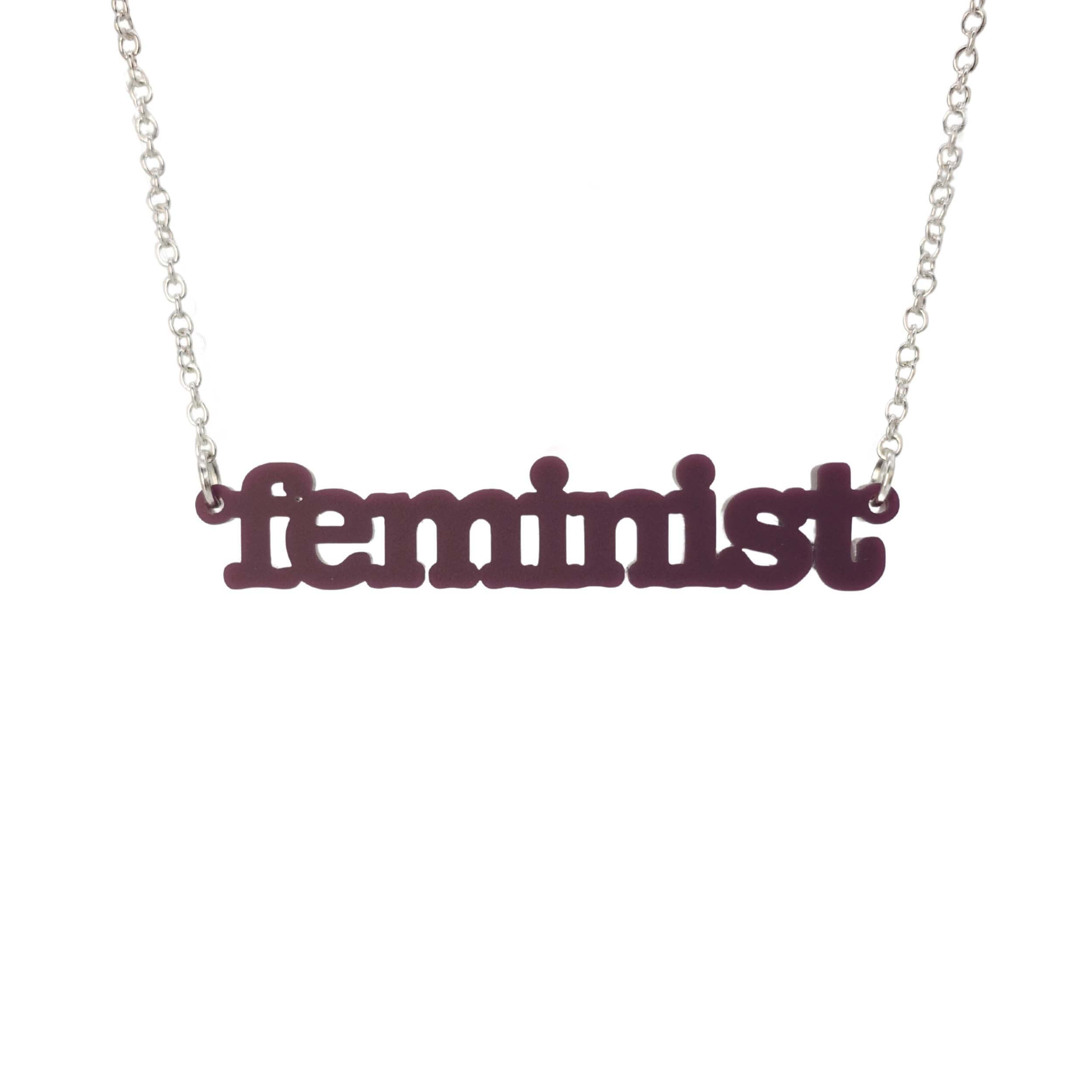 Cassis Feminist necklace shown hanging on a white background. 