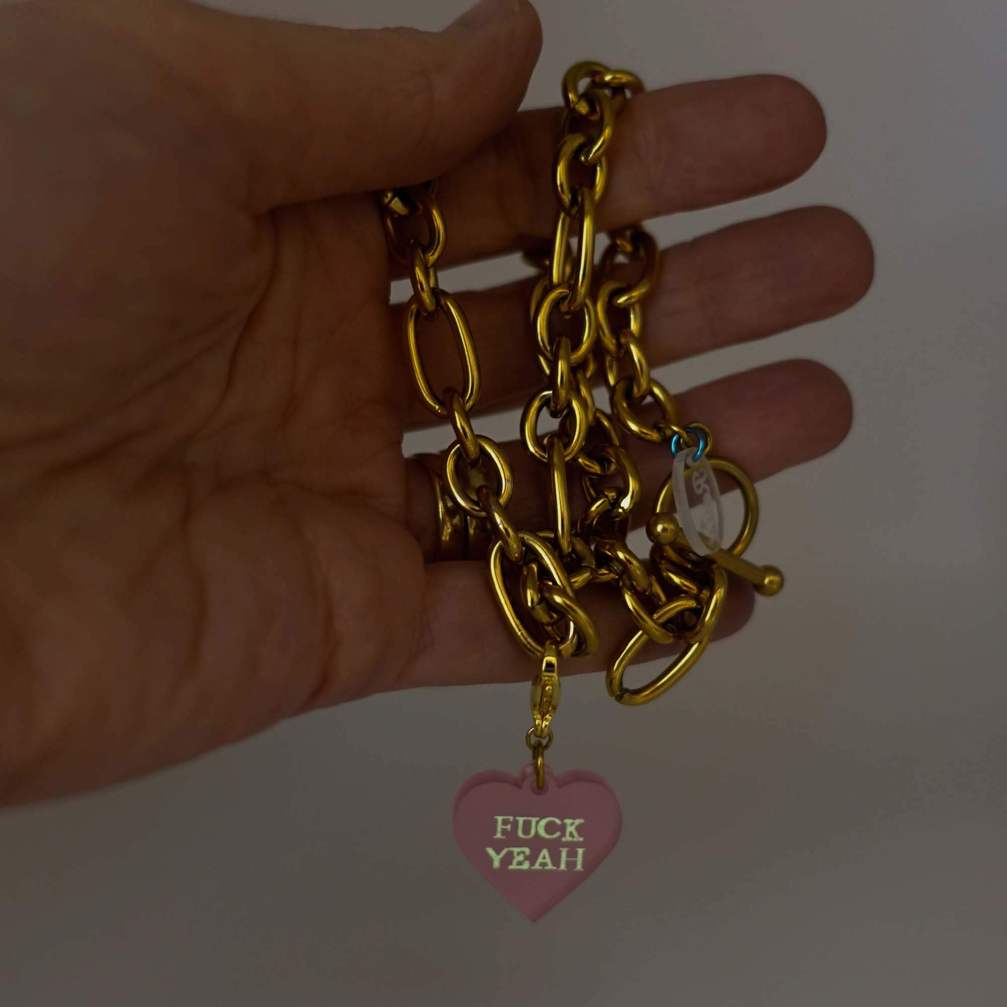 Chunky chain necklace with charm glowing in the dark. 