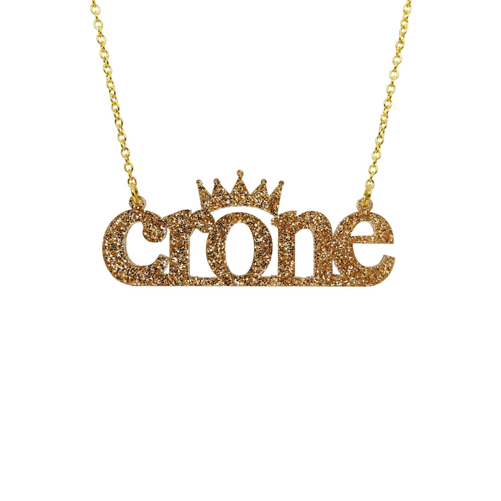 Crone necklace in gold glitter, shown hanging against a white background. 
