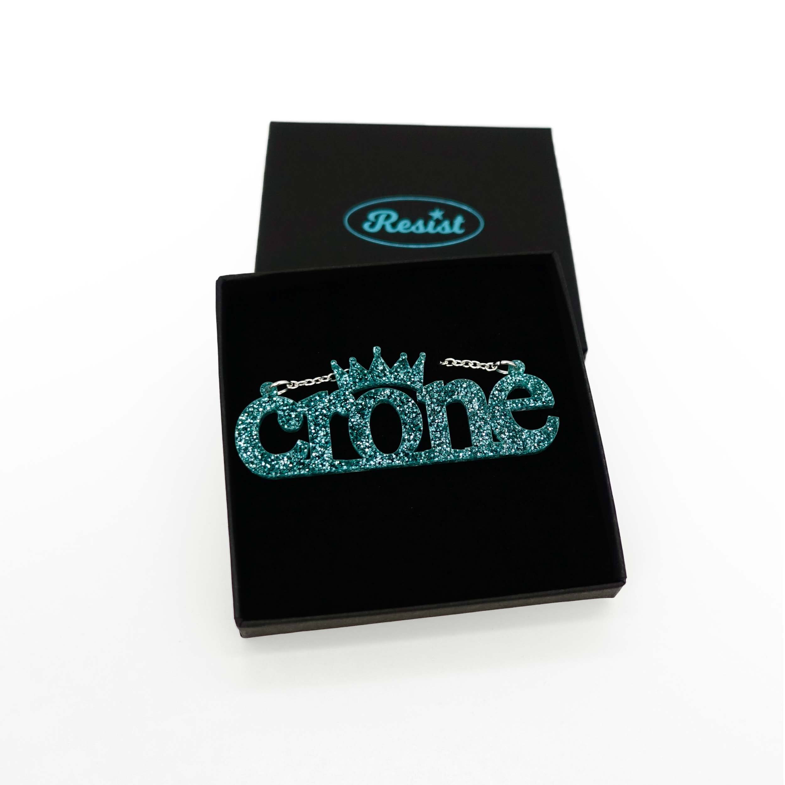 Crone necklace in teal glitter, shown in a Wear and Resist gift box. 