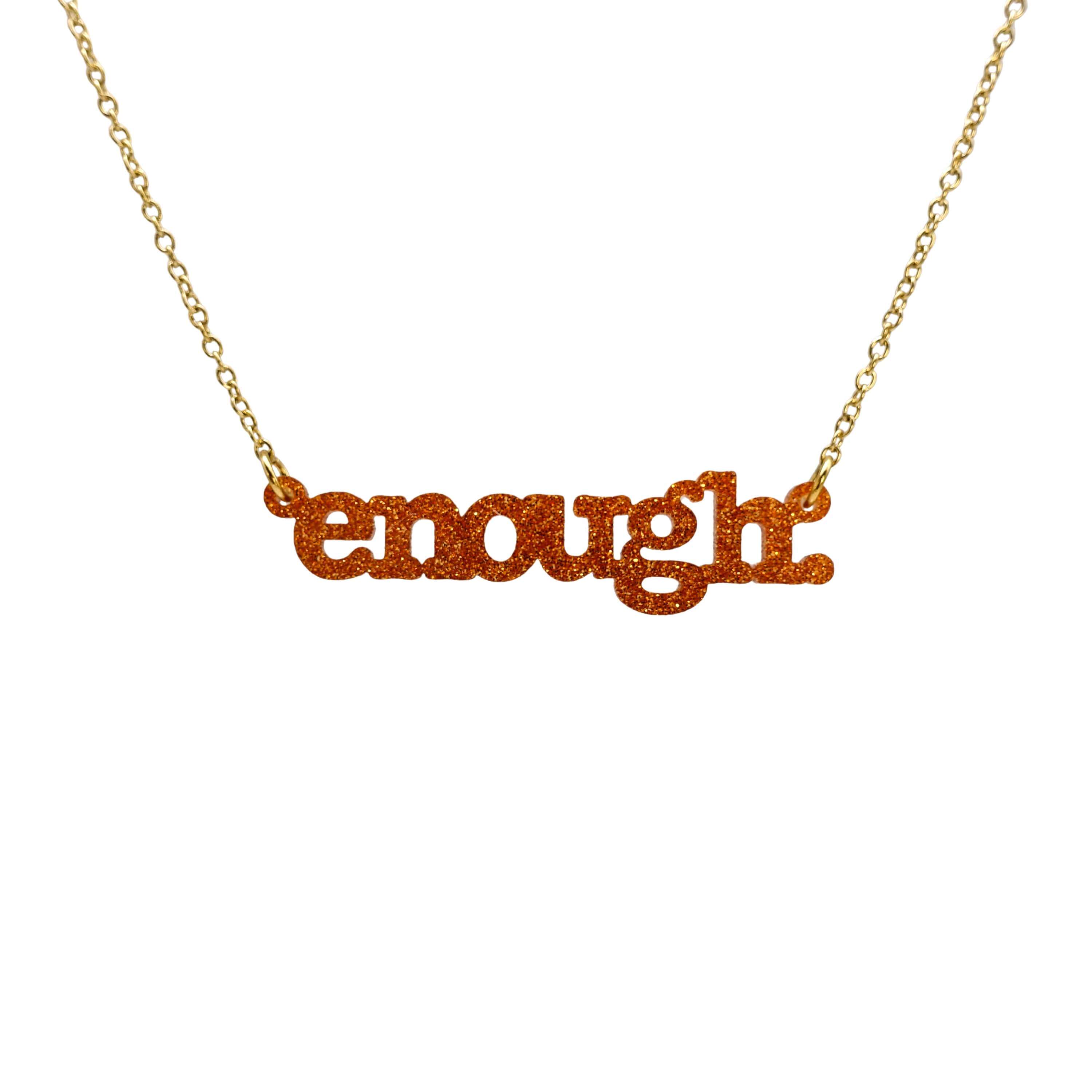 Typewriter Enough necklace in flame glitter shown hanging on a gold-plated stainless steel chain against a white background. 