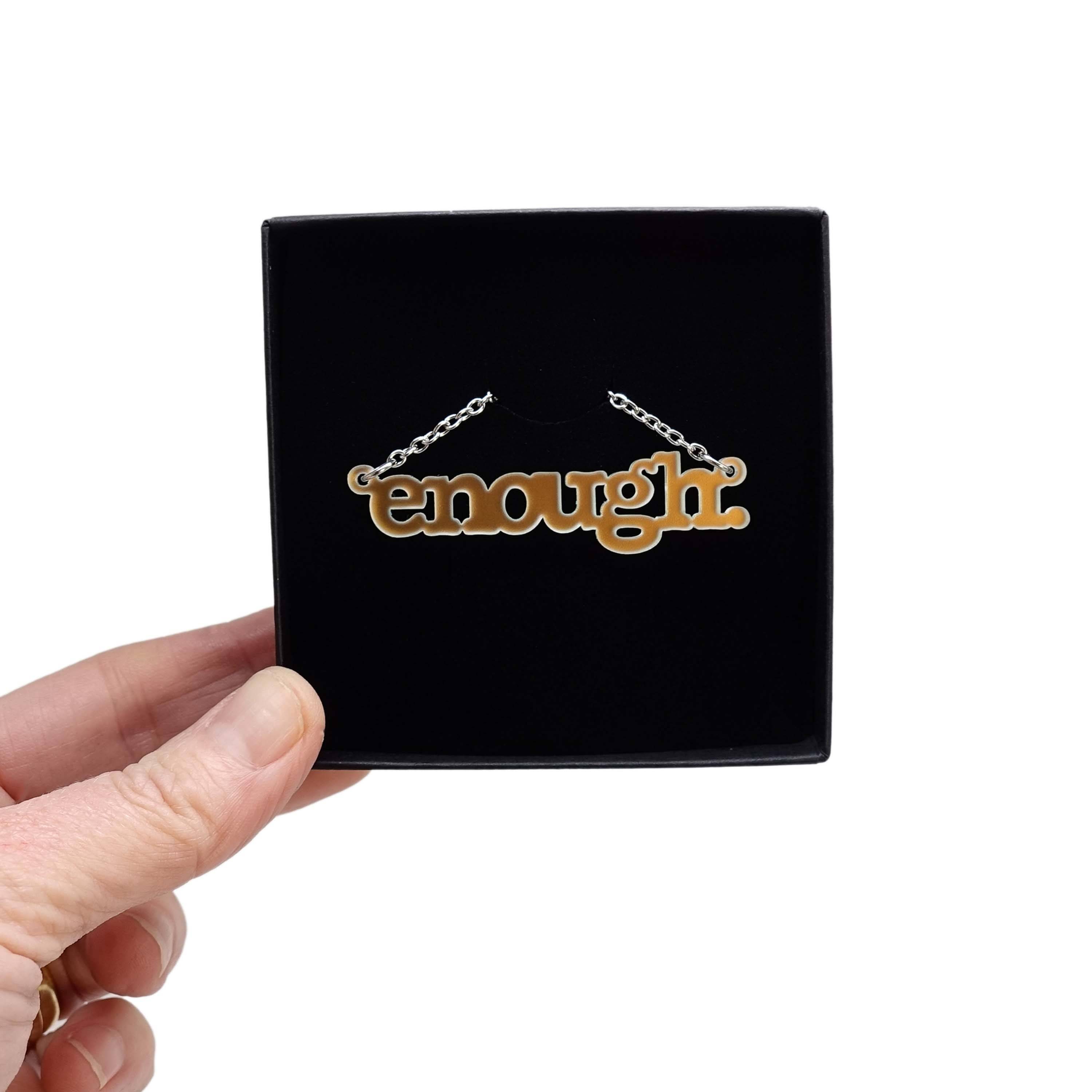Typewriter Enough necklace in matte iridescent shown in a Wear and Resist gift box. 