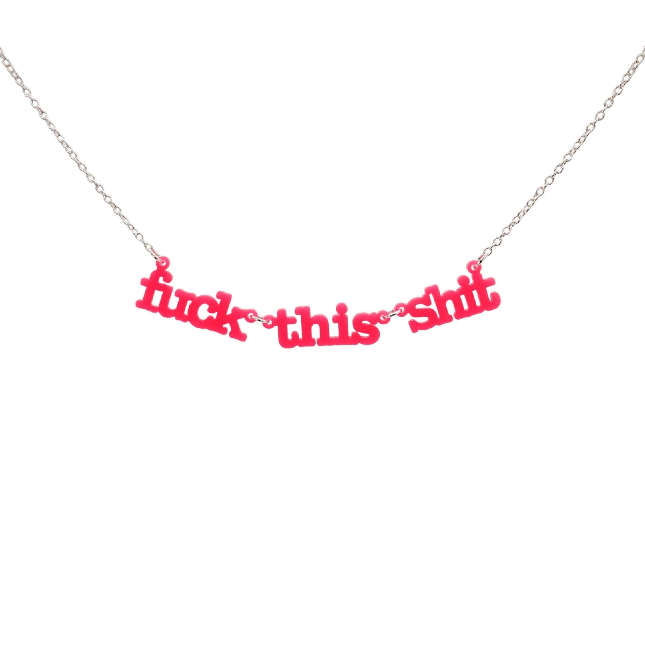 F*ck this sh*t necklace in hot pink shown hanging against a white backround. 